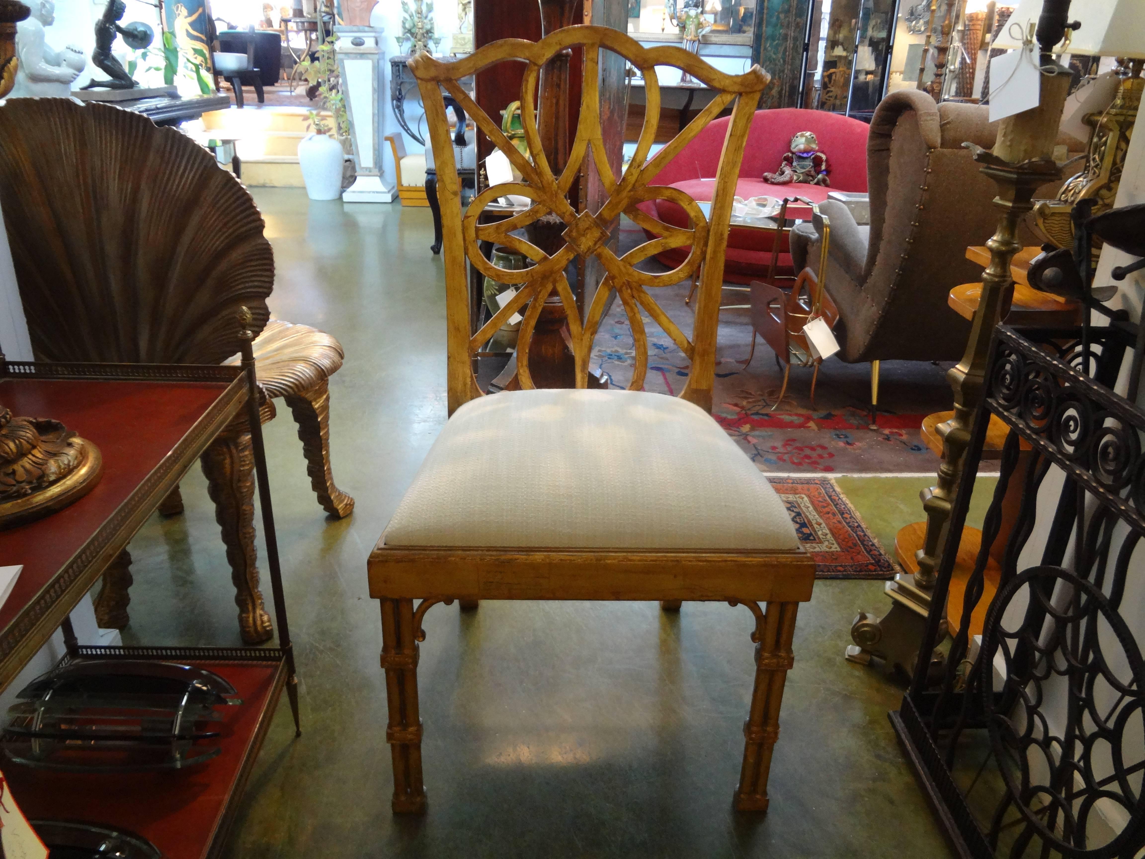 Beautifully detailed pair of Chinese Chippendale style giltwood chairs, circa 1970. This large pair of chinoiserie style giltwood side chairs or dining chairs have beautiful fretwork and have been newly upholstered in linen fabric.