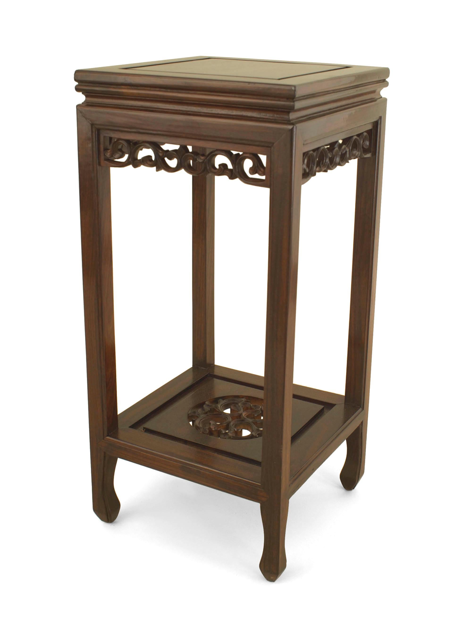 Pair of Asian Chinese (19/20th Cent) rosewood pedestals with square tops and a carved apron having a filigree carved bottom edge with a carved and filigree bottom shelf.
