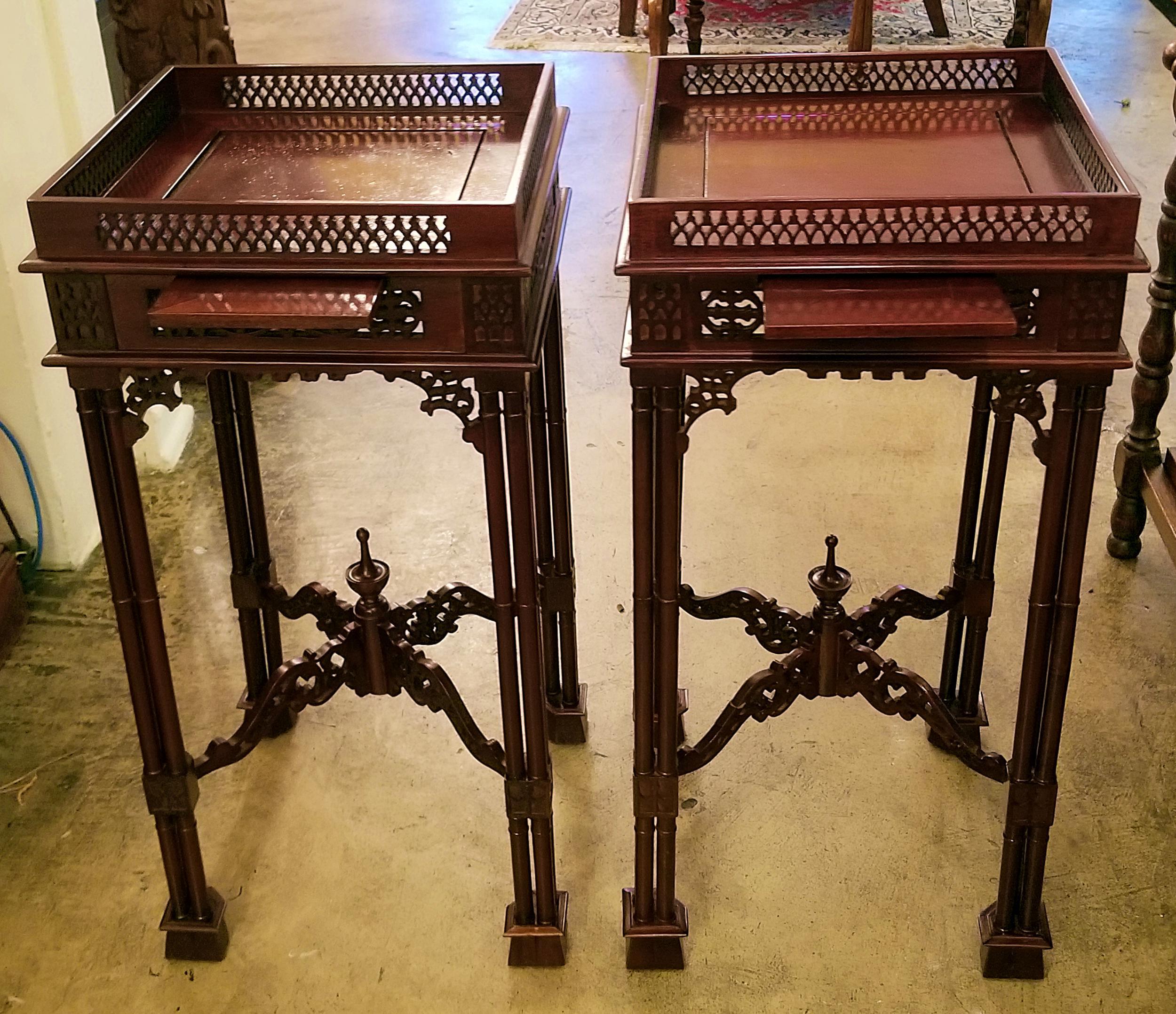 Presenting a lovely pair of Chinese Chippendale style tea tables.

Made in Britain of mahogany, circa 1920.

A matching pair. The top gallery edged with a fretwork panel on all sides. Each has a sliding shelf for resting a cup or