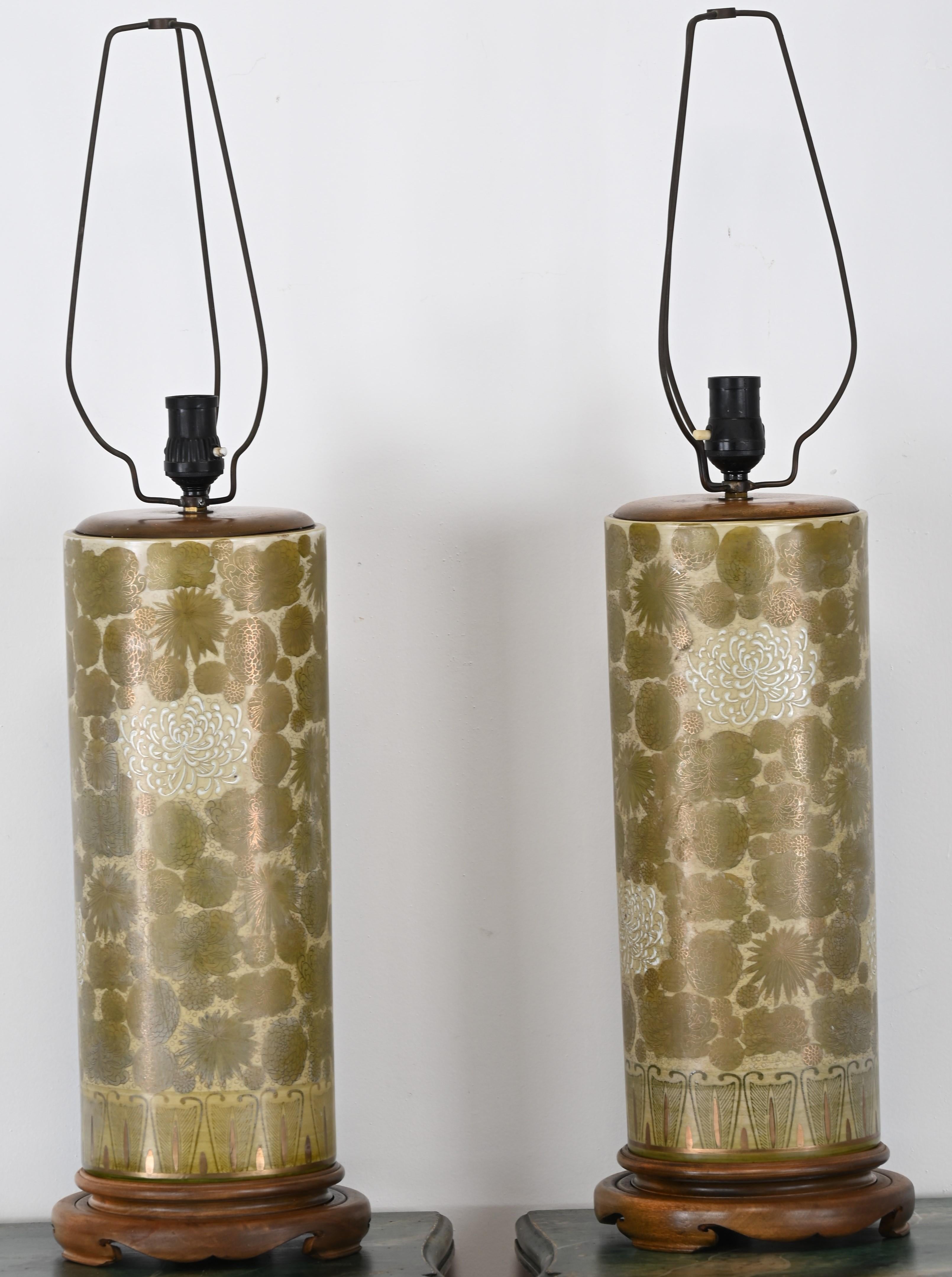 Estas elegantes lámparas de mesa Asian Modern, de la década de 1940, presentan cuerpos de porcelana pintados a mano en un sutil verde oliva con brillantes detalles dorados. El motivo de crisantemos, intercalado con estilizados motivos florales y