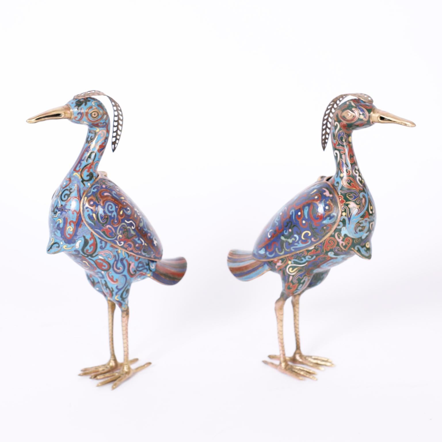 Pair of life size Chinese cloisonné or enamel on copper birds decorated with elaborate floral designs, having brass crests, beaks, and feet and removable wings.