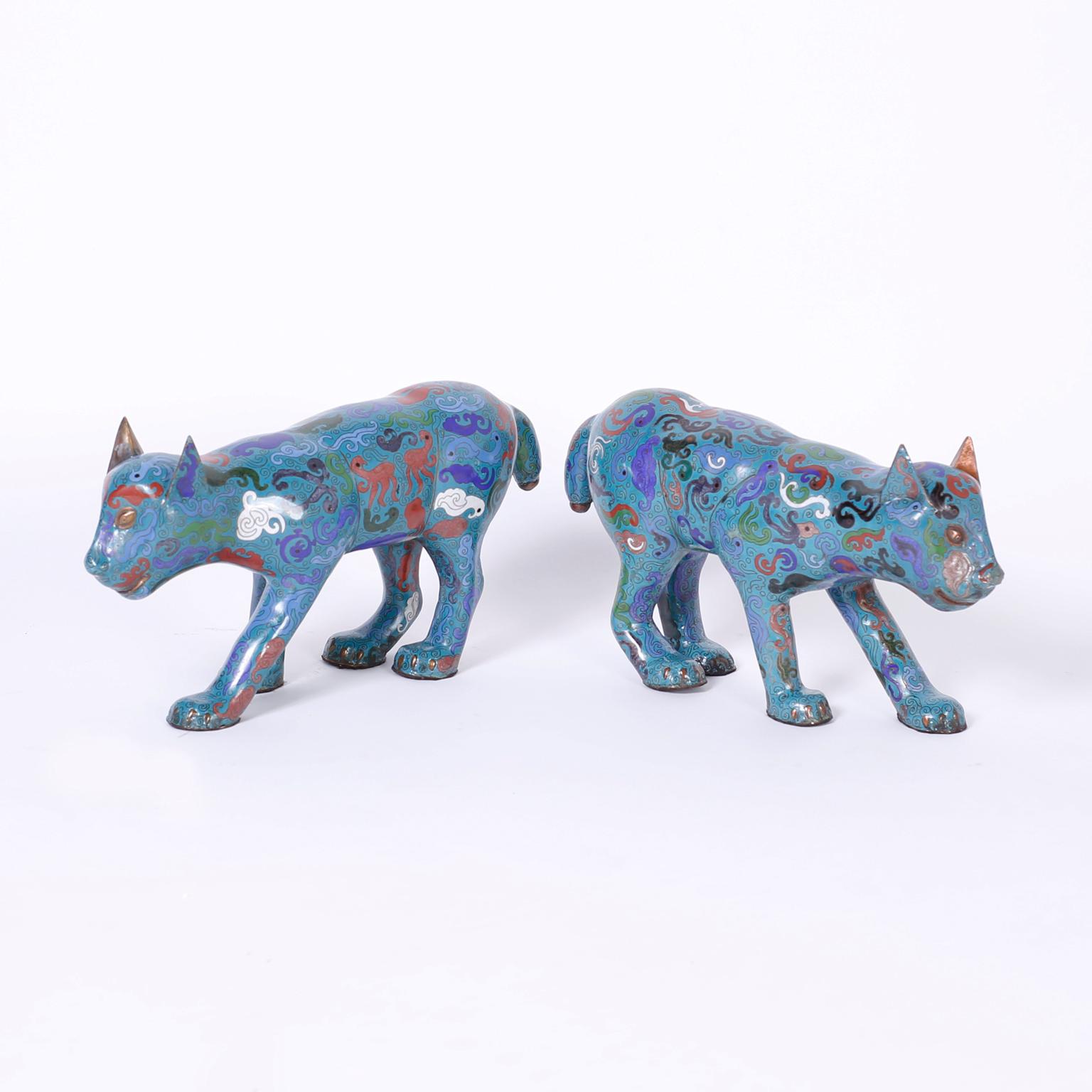 Pair of Chinese cloisonné or enamel on copper cats in a familiar stalking pose decorated with symbolic biomorphic designs over an alluring blue background.