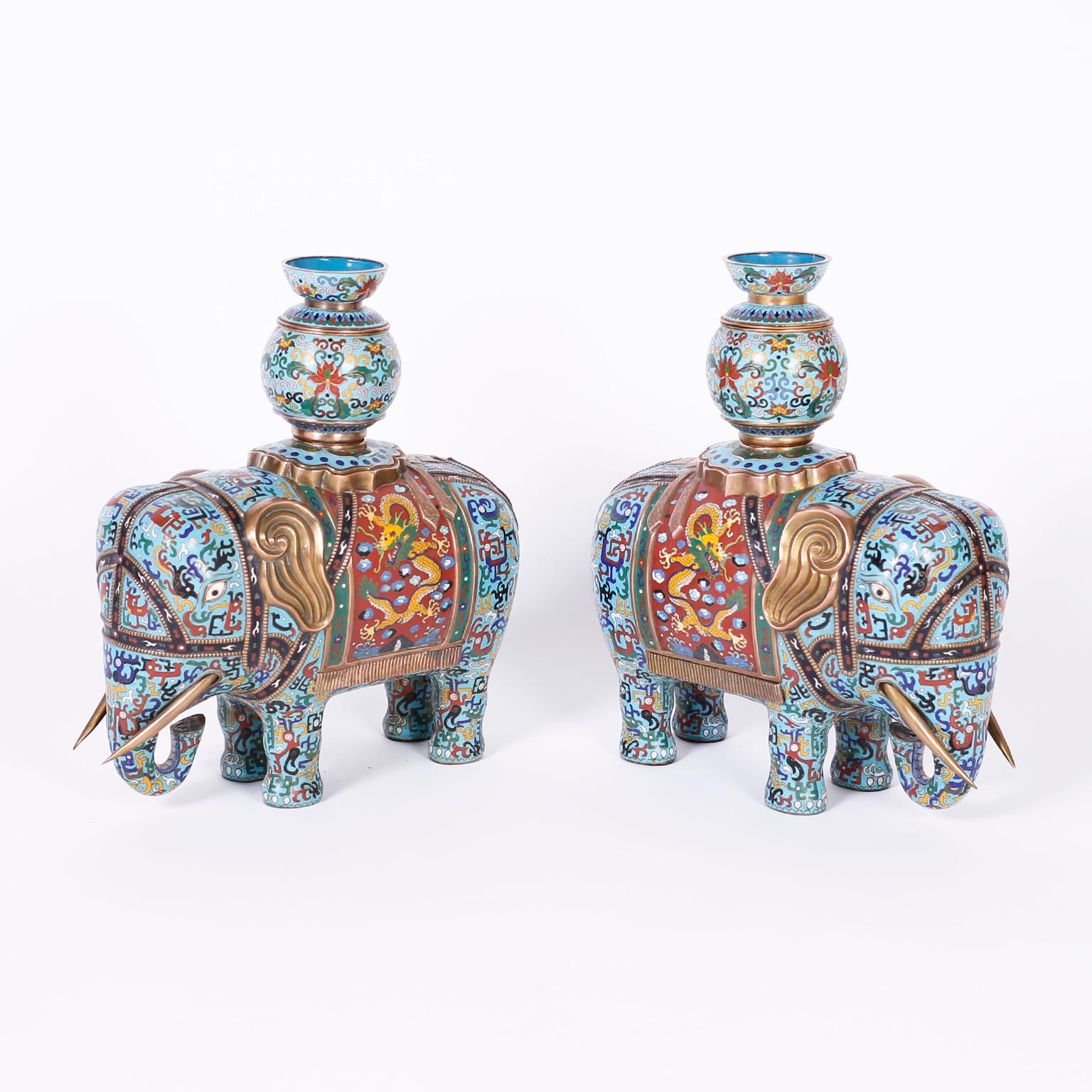 Pair of antique Chinese cloisonné or enamel on copper elephants decorated with colorful geometric symbols over an alluring blue background and contrasting saddle blanket with a gold dragon, the incense burner tops are conveniently removable.