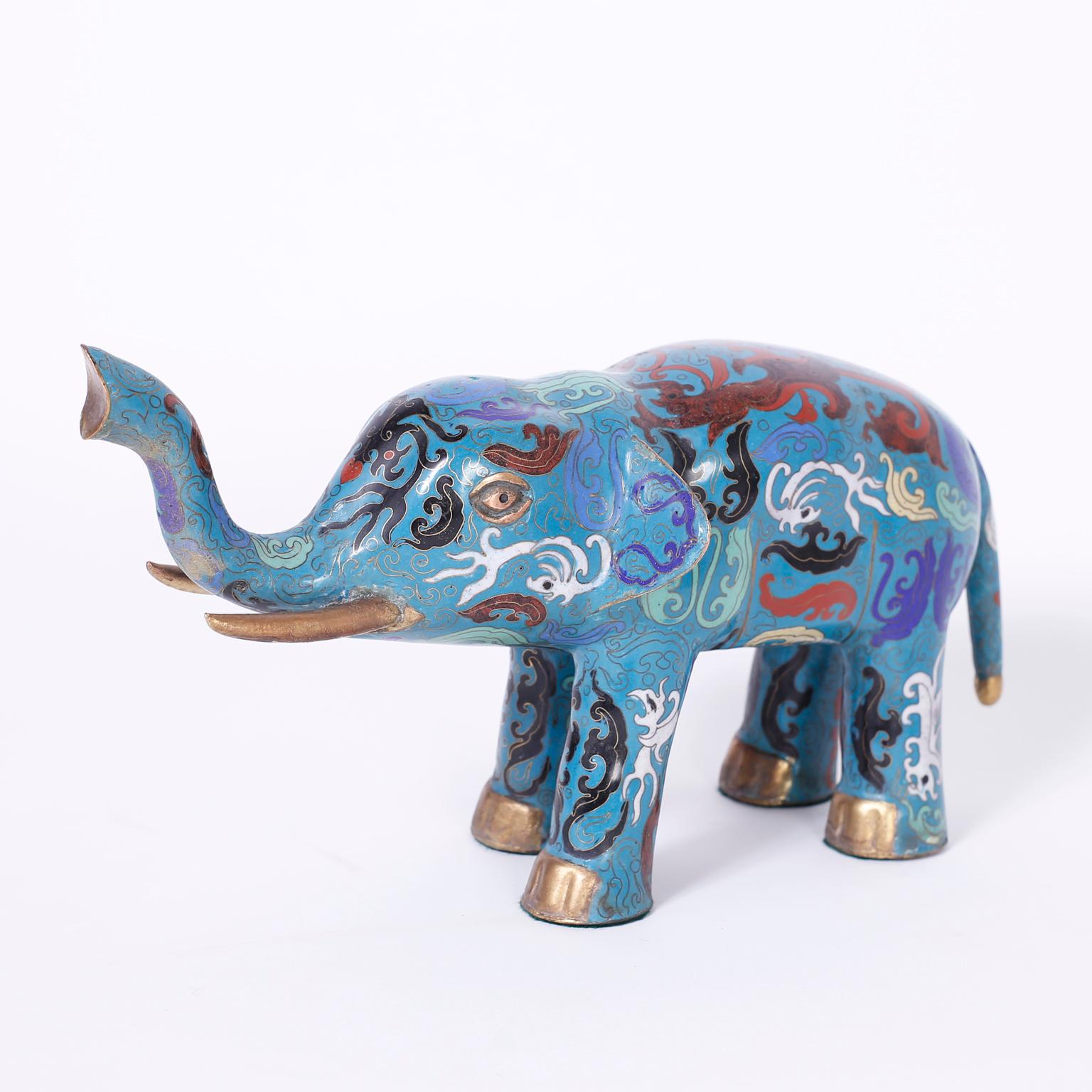 Charmante paire d'éléphants chinois en cloisonné ou en émail sur cuivre, décorés de motifs biomorphiques symboliques sur un fond bleu séduisant.
 