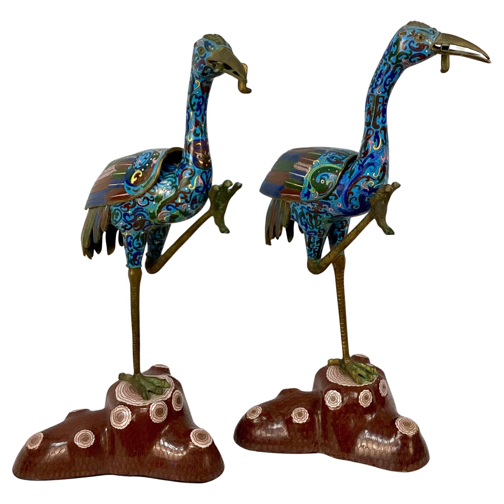 Unique pair of Chinese Cloisonne enamel cranes, possibly from the Qing dynasty. Rich colors of blue, yellow, pink, and green, legs are brass on a pink and brown base. Wings on back are removable to use crane as a censer to burn incense. This elegant