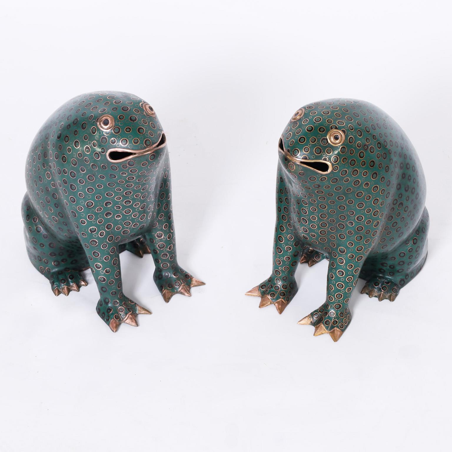 Rare and remarkable pair of whimsical Chinese cloisonné or enamel on brass frogs with a stylized form and decorated with repeating spots on a green background.
