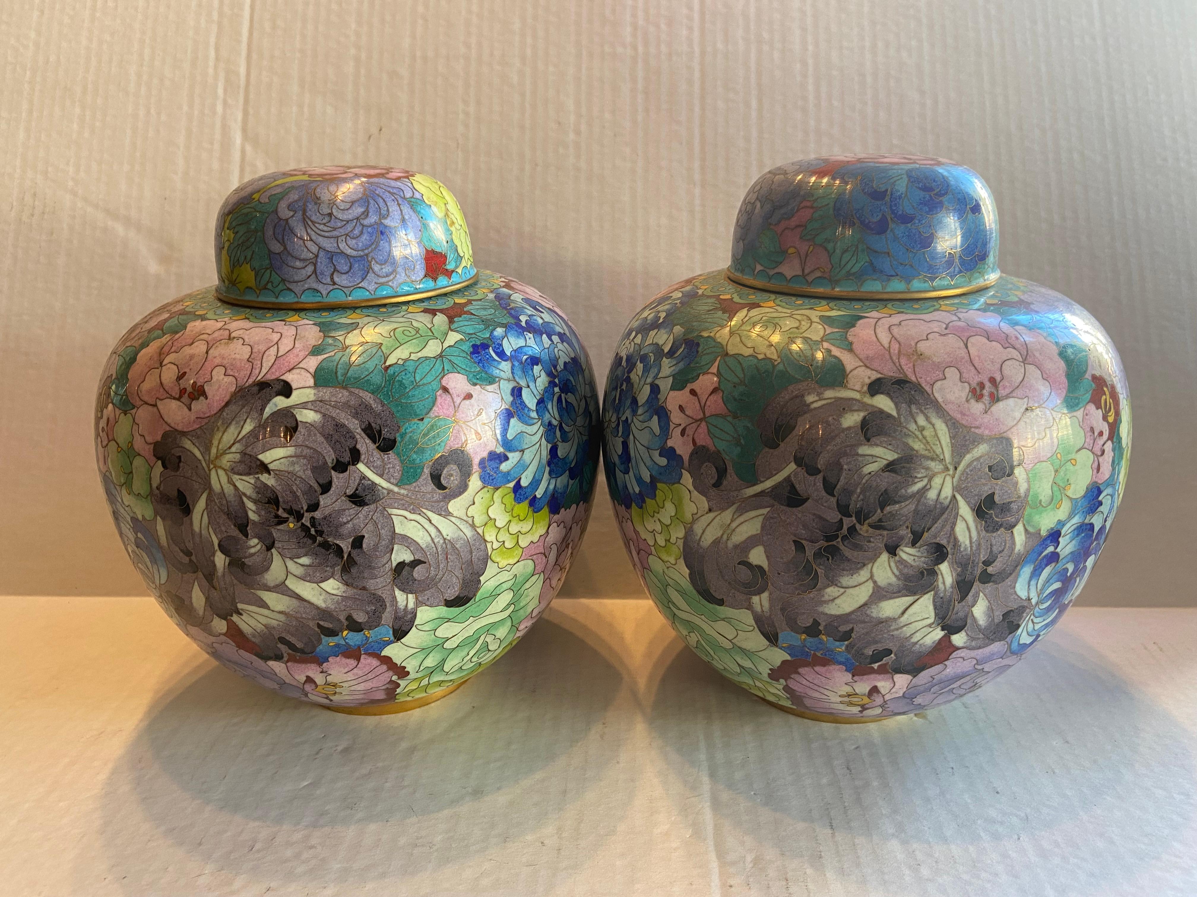 Pair of Chinese Cloisonné Mille Fleur Jars with Lids. Cloisonné is an ancient technique for decorating metalwork objects with colored material held in place or separated by metal strips or wire, normally of gold. Cloisonné enamel objects are worked