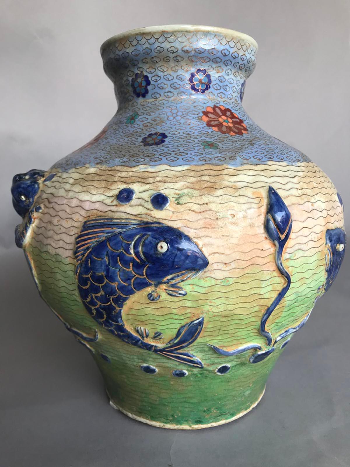 Pair of mid 20th century Chinese cloisonné over ceramic vases. This fun and whimsical pair depicts carp fish in a water scene with possible lotus leaf or lily pad and other water creatures. Fish is one of the oldest traditional animal symbols in