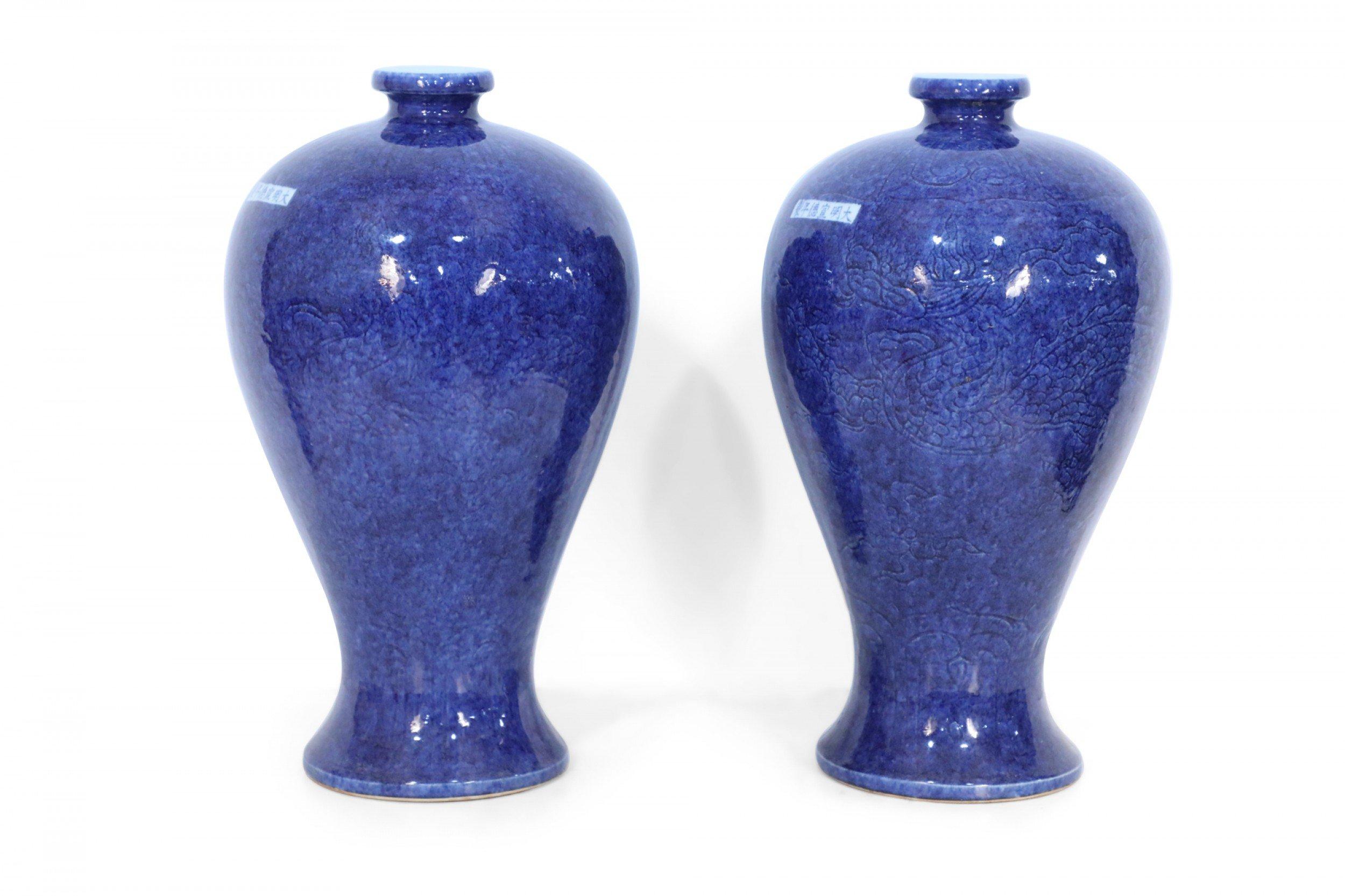 PAIR of Chinese cobalt blue vases in Meiping shapes, covered with incised patterns of dragons and curvilinear designs, and bearing small white rectangles featuring blue characters (PRICED AS PAIR).

Condition: Good; Wear consistent with age and use