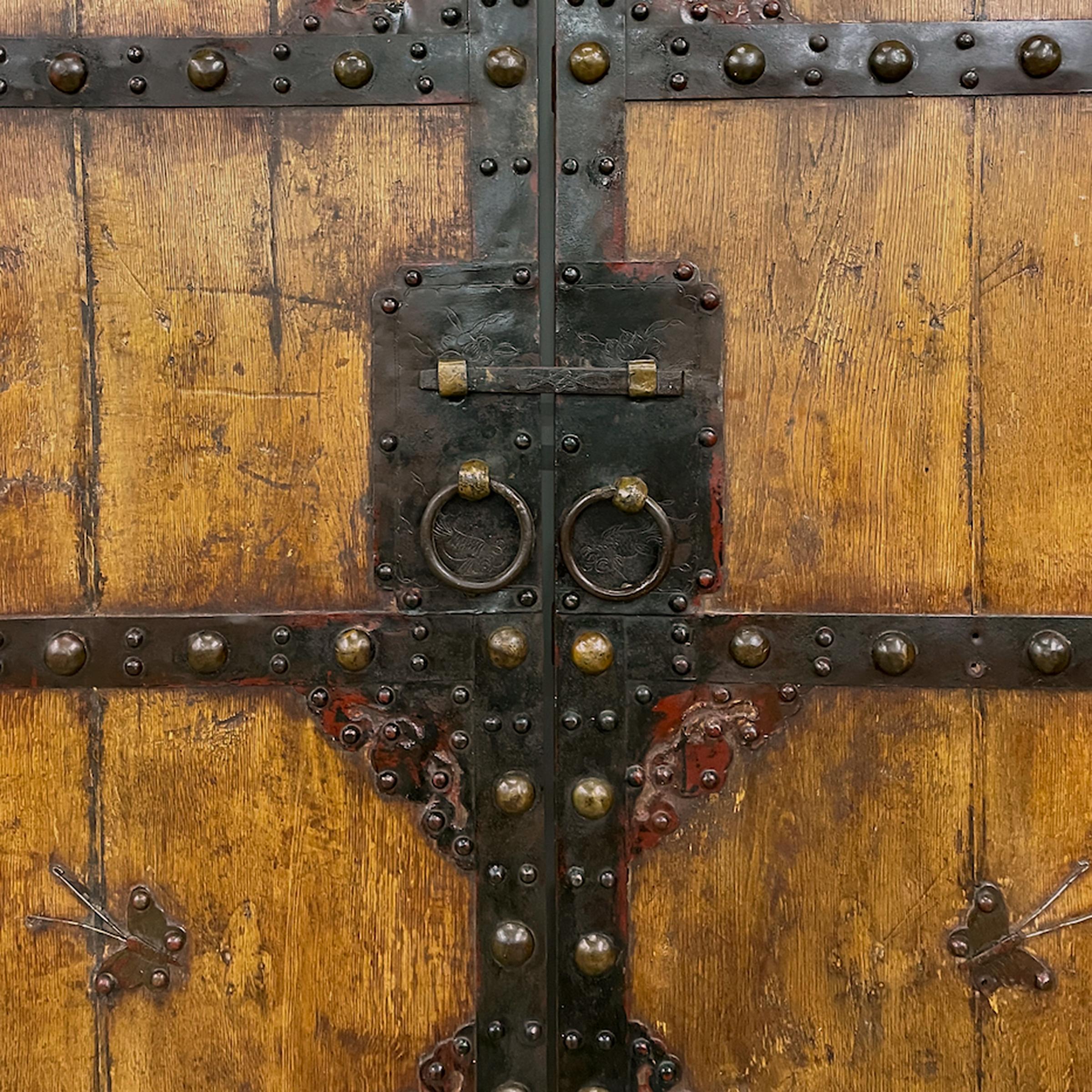 This imposing set of doors dates to the mid-19th century and once enclosed the inner courtyard of a Qing-dynasty home in northern China. The double doors are crafted of northern elm (yumu), a common hardwood appreciated for its strength, warm