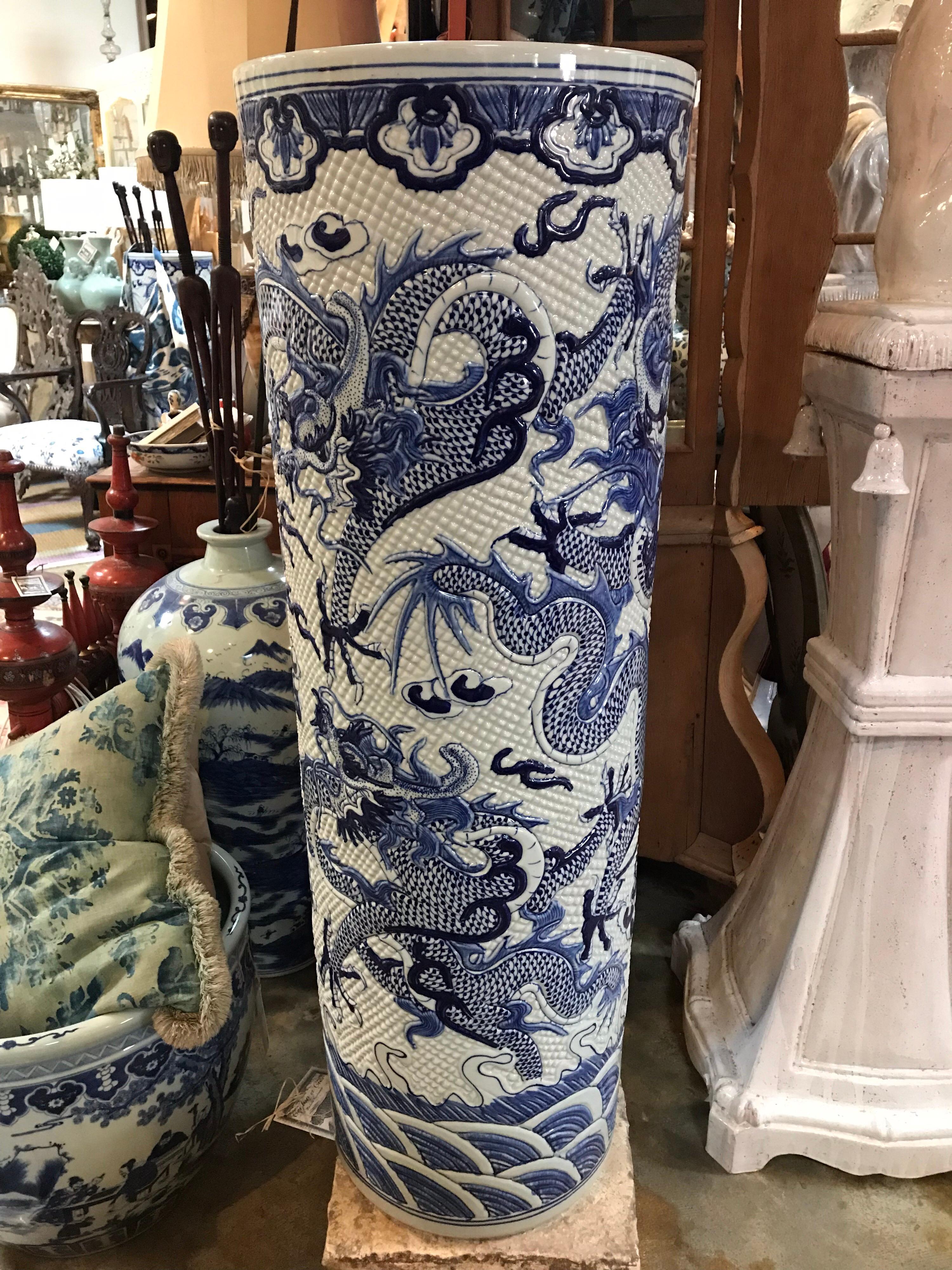 Pair of oversized Chinese cylindrical vases. Beautifully detailed ceramic jars with blue and white dragons. Textured surface. Over scaled for visual importance.