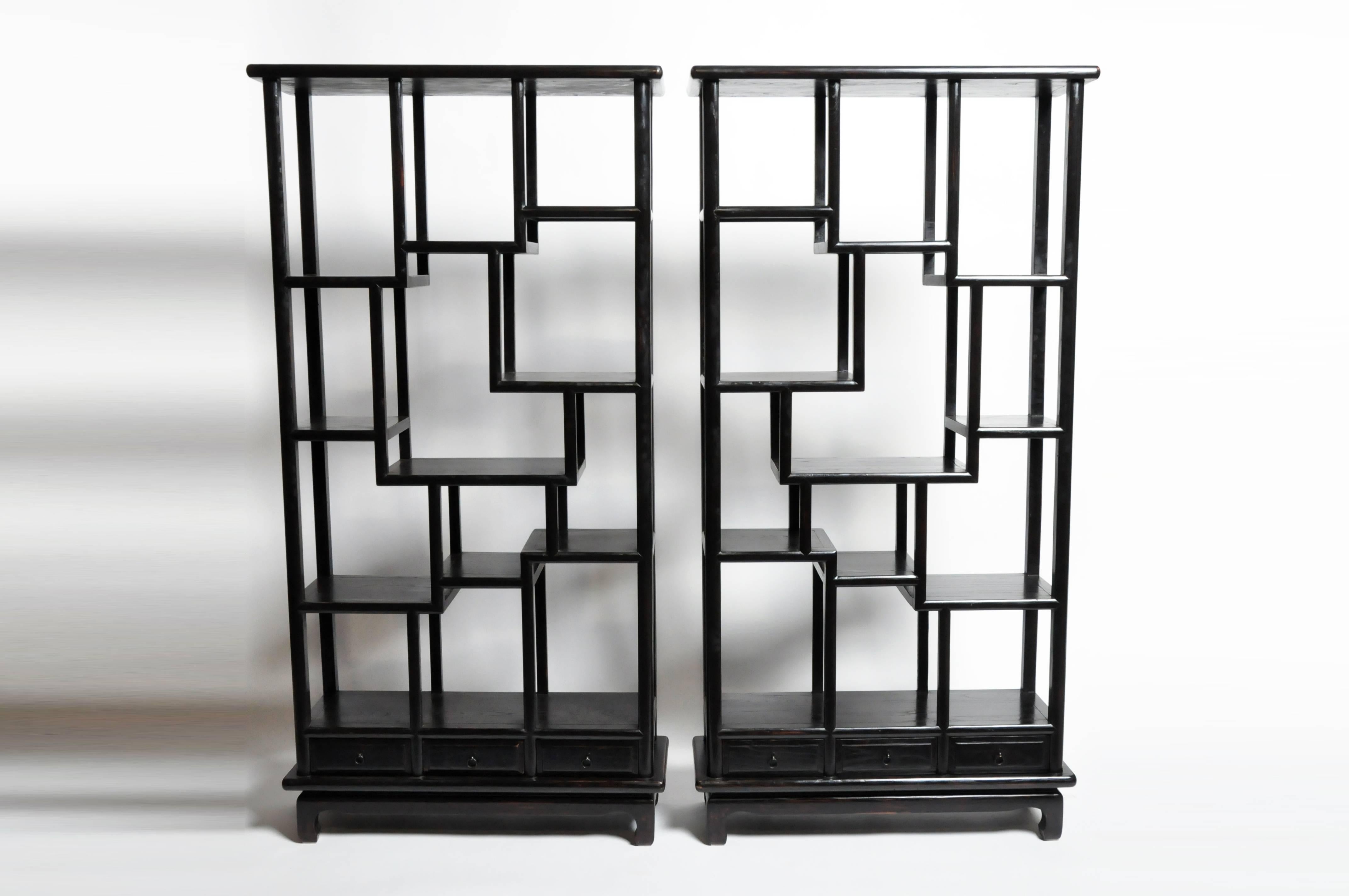 These Chinese display cabinets are made from reclaimed elm wood and are from Jiangsu, China. They each feature mortise and tenon joinery,  elegant lattice work that can function as shelves and display space; they also have three drawers on the
