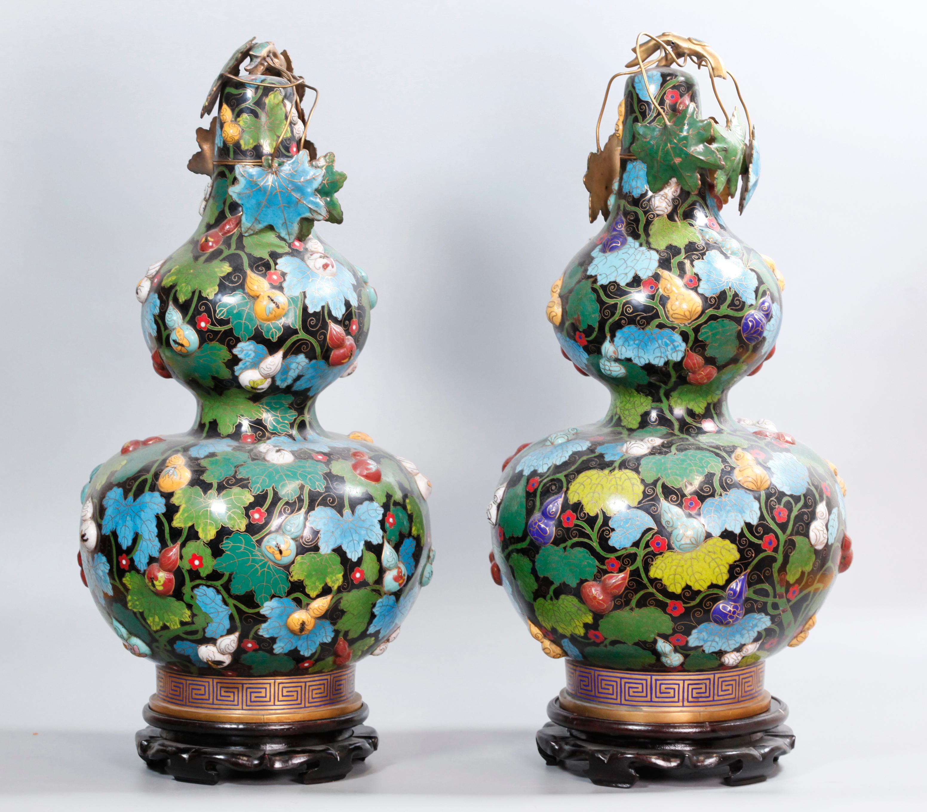 provenienza: Christie's; le basi in legno mostrate nelle immagini sono incluse con questi vasi; ogni vaso è decorato con zucche in miniatura in rilievo; dimensioni complessive di ogni vaso con base in legno (misure approssimative): 23in(H) x