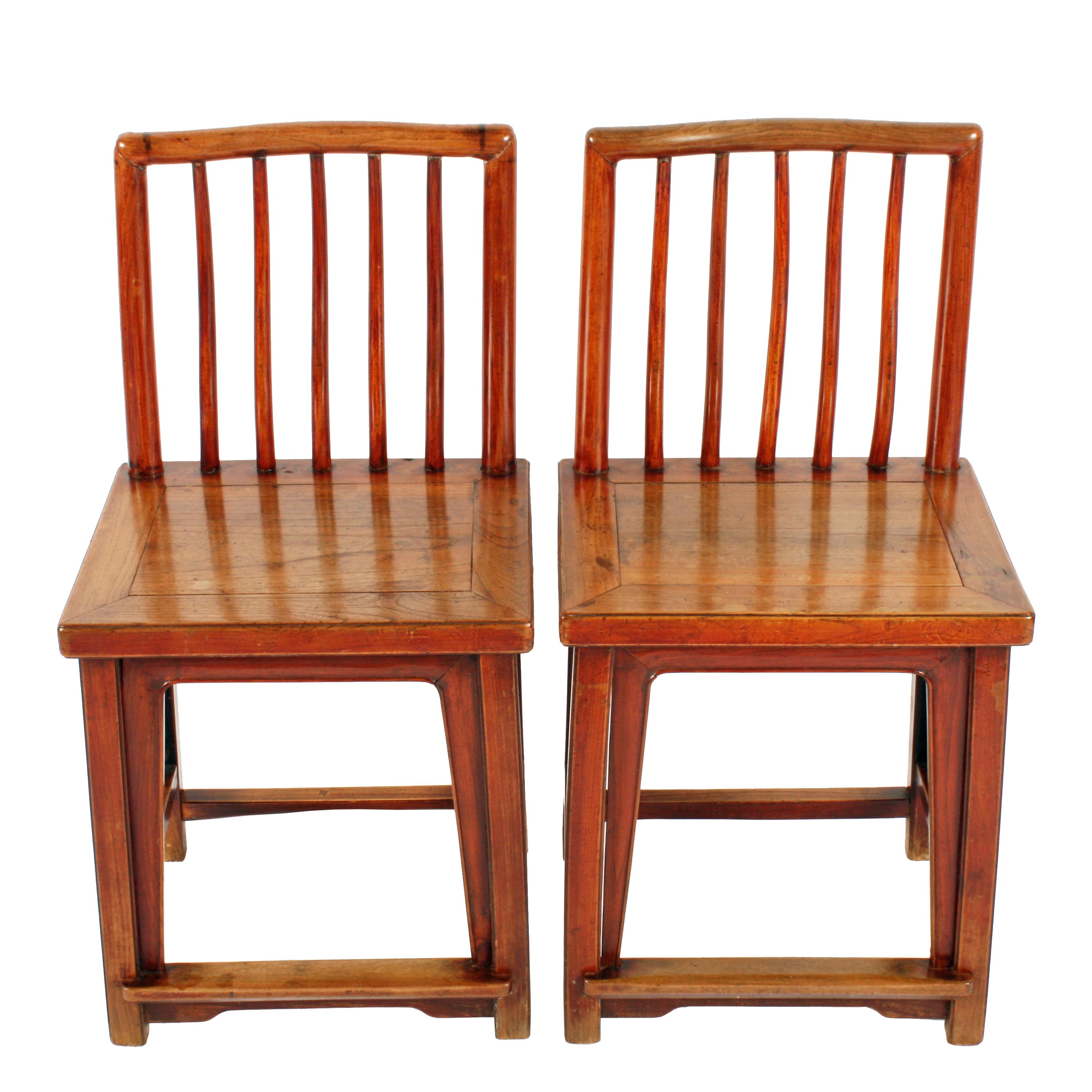 A pair of 19th century Chinese elm rose chairs.

The chairs are made from solid elm with a panel seat and square legs.

The back has five round spars inside a pair of uprights and a shaped top rail.

The chairs have stretchers between the legs