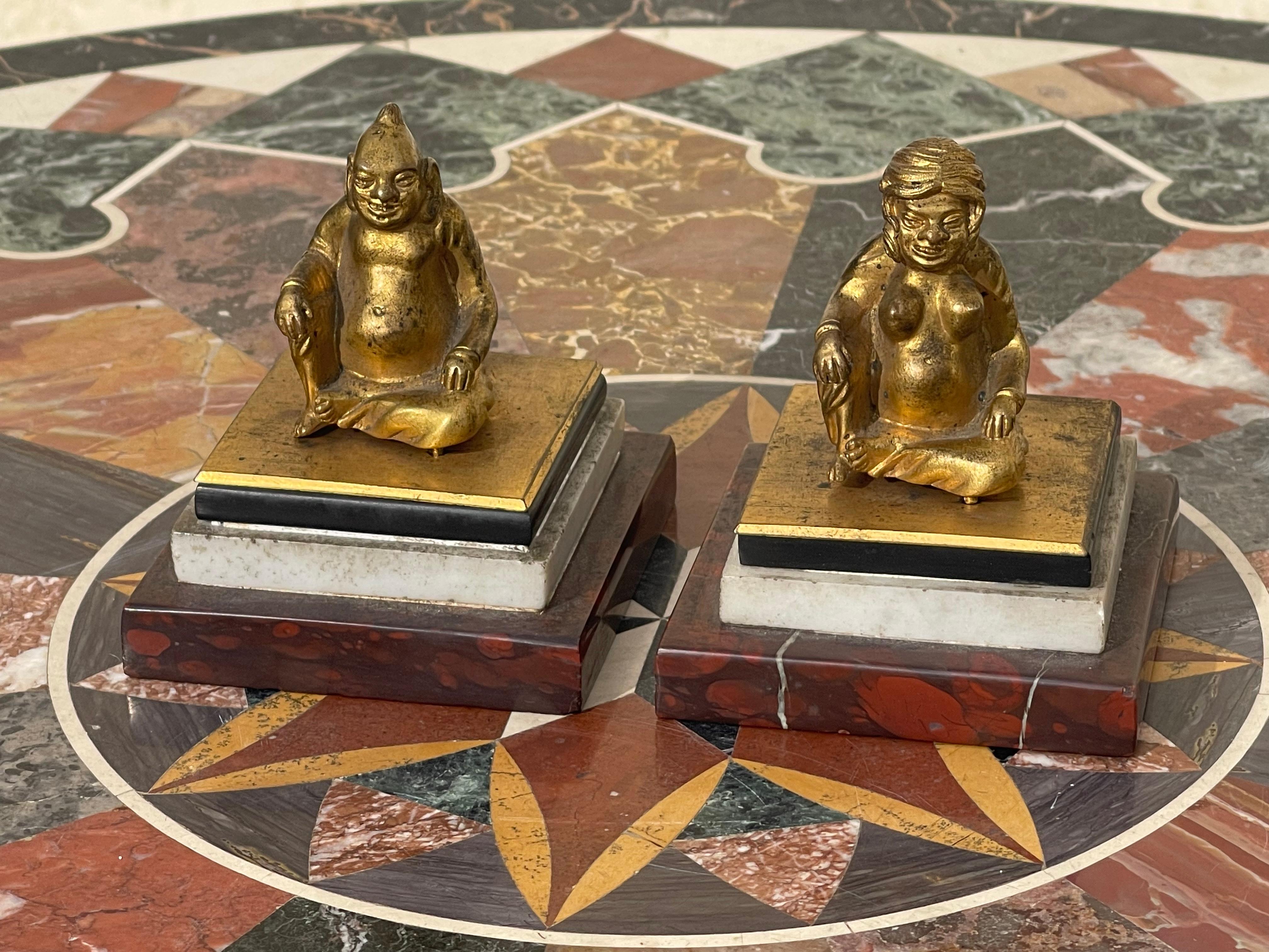 Pair of erotic bronzes representing a Chinese couple resting on a base composed of three different marbles: cherry red, carrara white and finally black. The characters tilt at the back and reveal their posteriors. They are in good