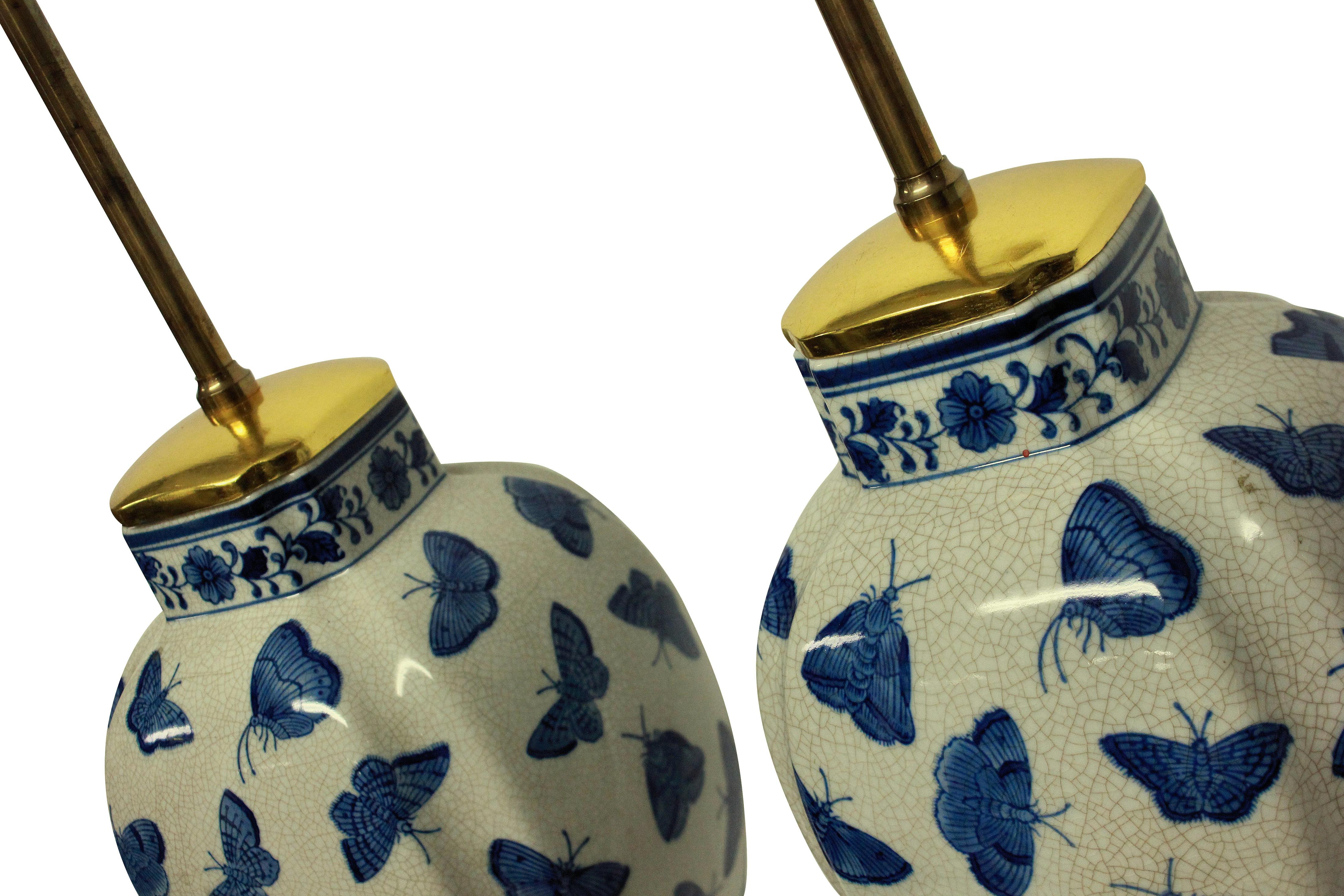 A pair of charming Chinese export blue and white porcelain vase lamps depicting butterflies. With water gilded and burnished bases and top sections. Newly electrified.