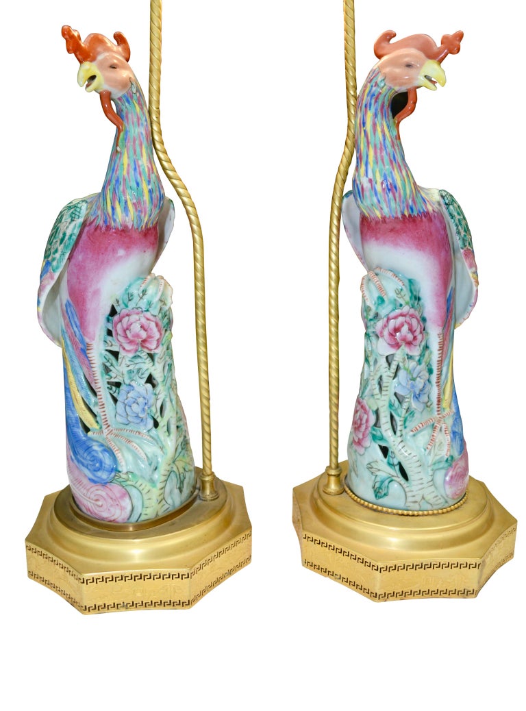 A pair of mid-20th century Chinese Export Famille Verte glazed porcelain Fenghuang Phoenix birds perched on an open rockery converted into lamps. The figures are stamped at the base (refer to photos) and are presented on stepped Chinese brass
