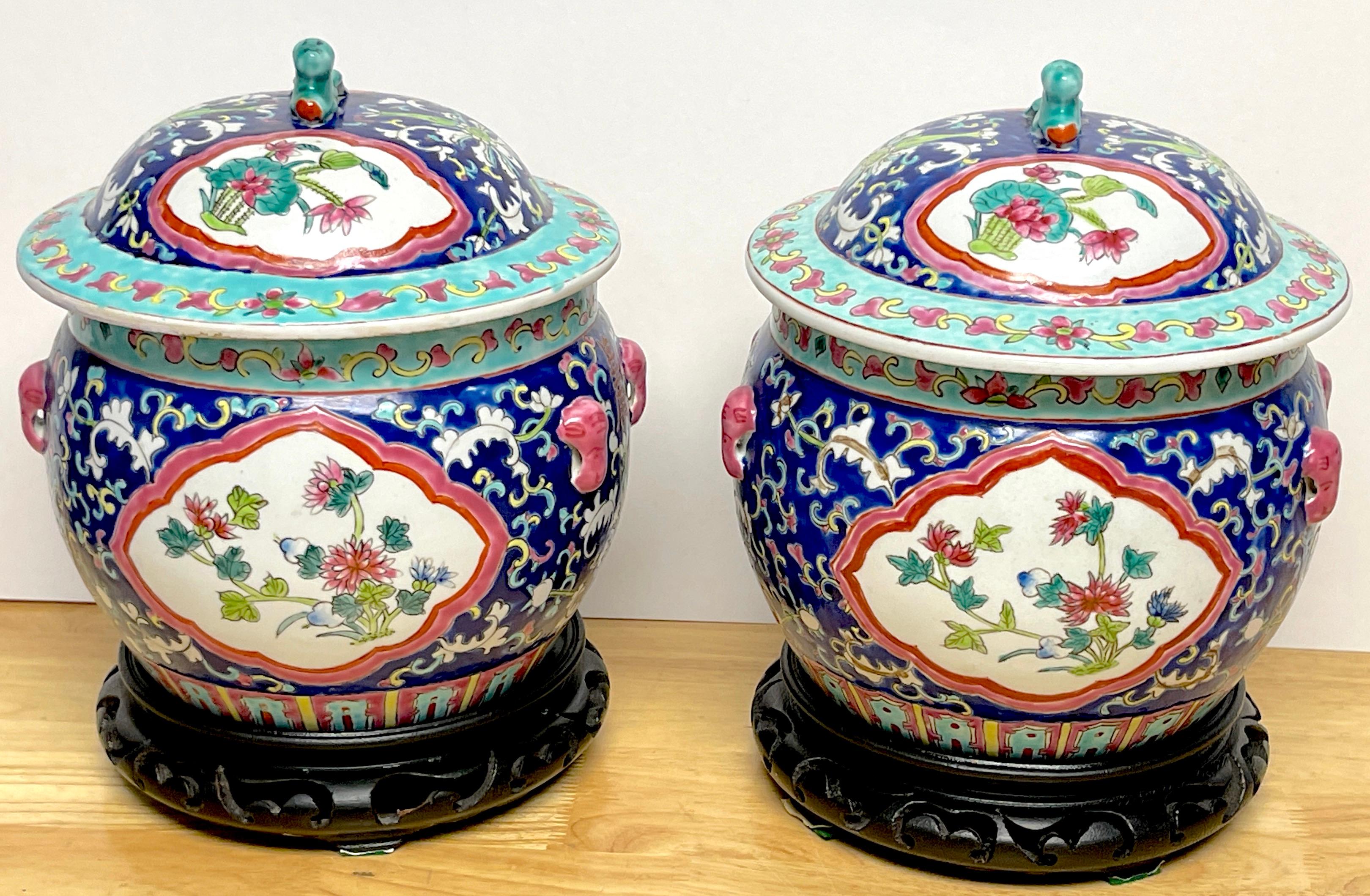 Pair of Chinese Export Famille-Rose Enameled Covered Urns & Stands 
China, 20th Century 

A nice pair of intricately and vibrantly decorated famille-rose covered urns, would make beautiful cachepots, if used without the lids.  Each one marked with a