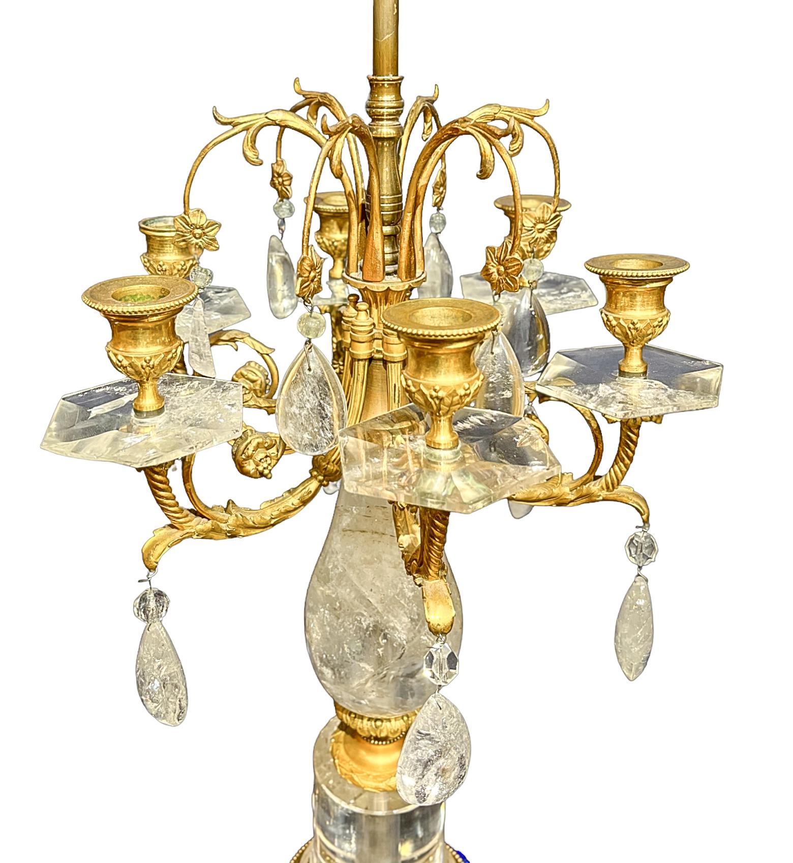 Antique rock crystal clock with gilt bronze branches and ornamentation. Tear drop cut rock crystals hang from the lamp's ornate branches decorated with scrolling and foliage forms. All resting upon a raised lapis base. 

Dimensions: 35 h x 22w In.
