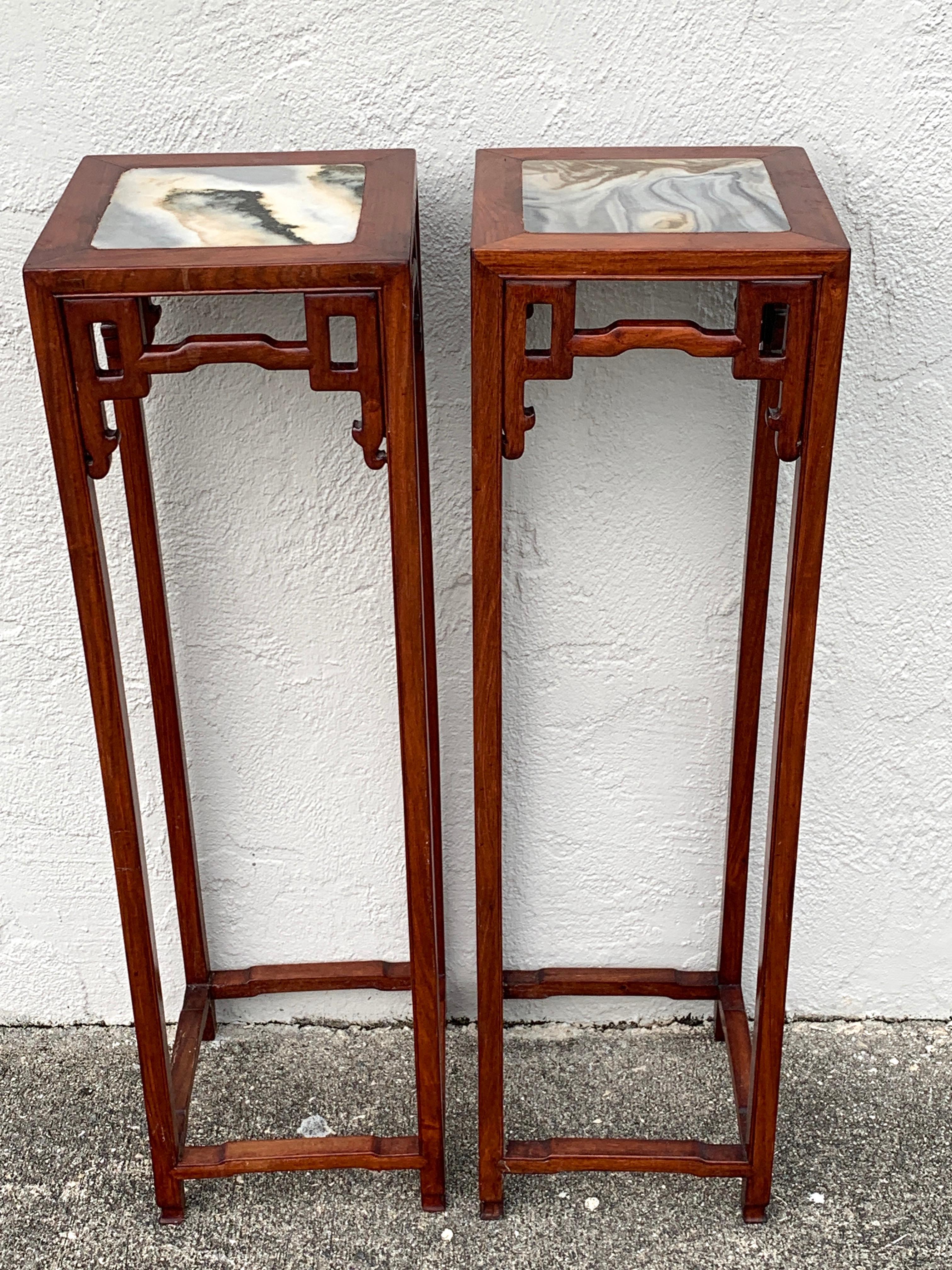 Pair of Chinese export hardwood and marble pedestals, each one of square form with inset marble tops, on subtly carved pedestal bases with lower stretchers.