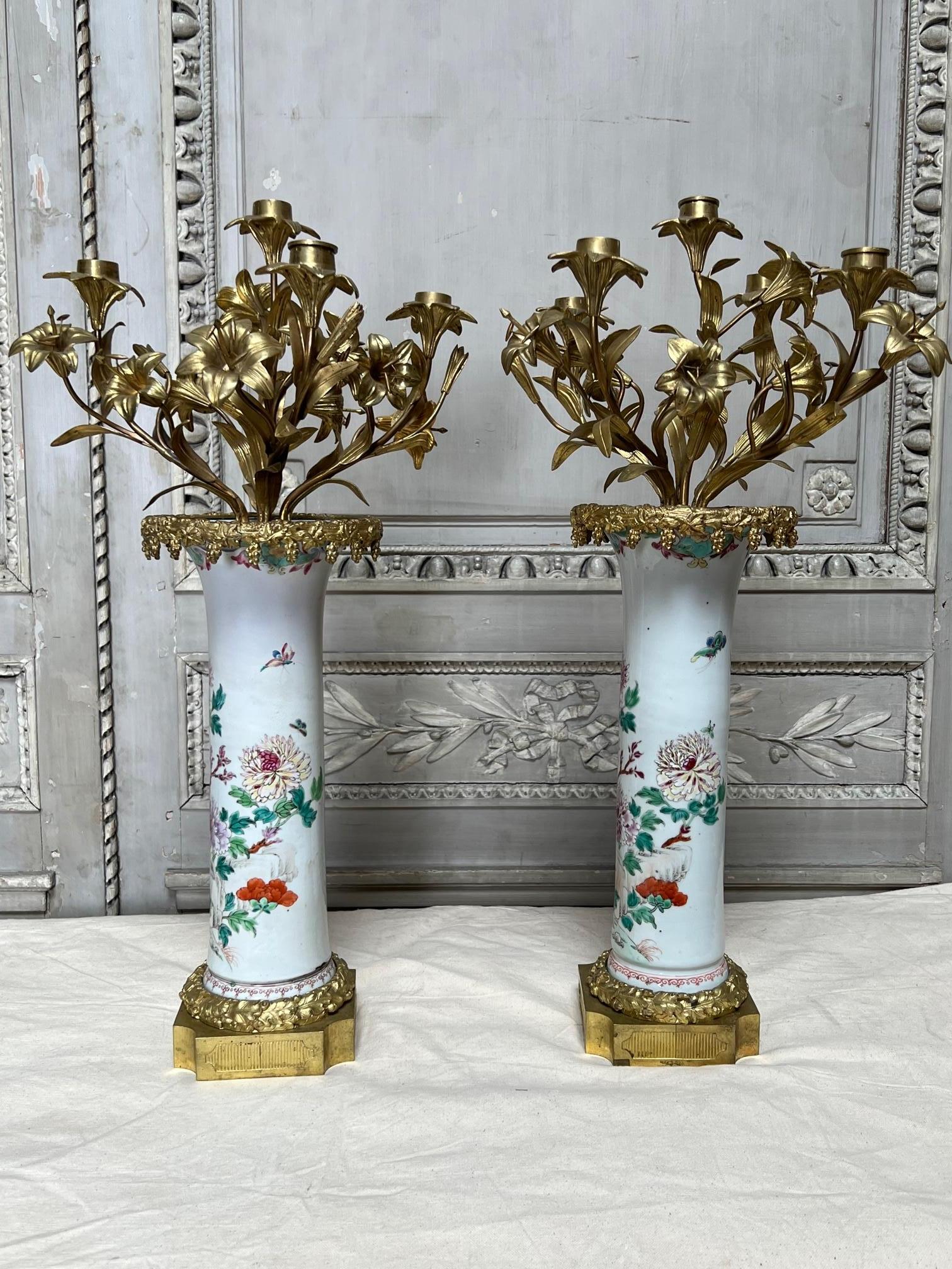 A pair of candelabra consisting of a pair of 18th century Chinese export vases mounted in 19th century French bronze in the Louis XVI style. The porcelains are very decorative and do have some damages that are underneath the bronze mountings that do