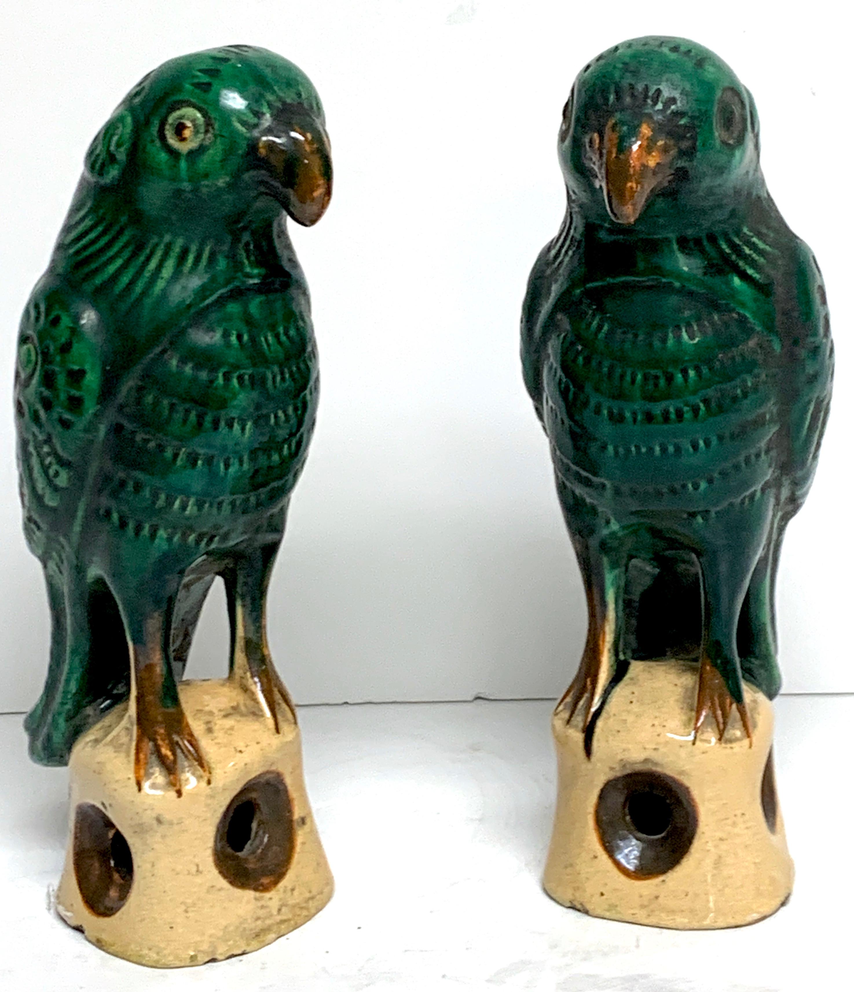 Pair of Chinese export porcelain green glazed parrots, each raised on an openwork 2.25