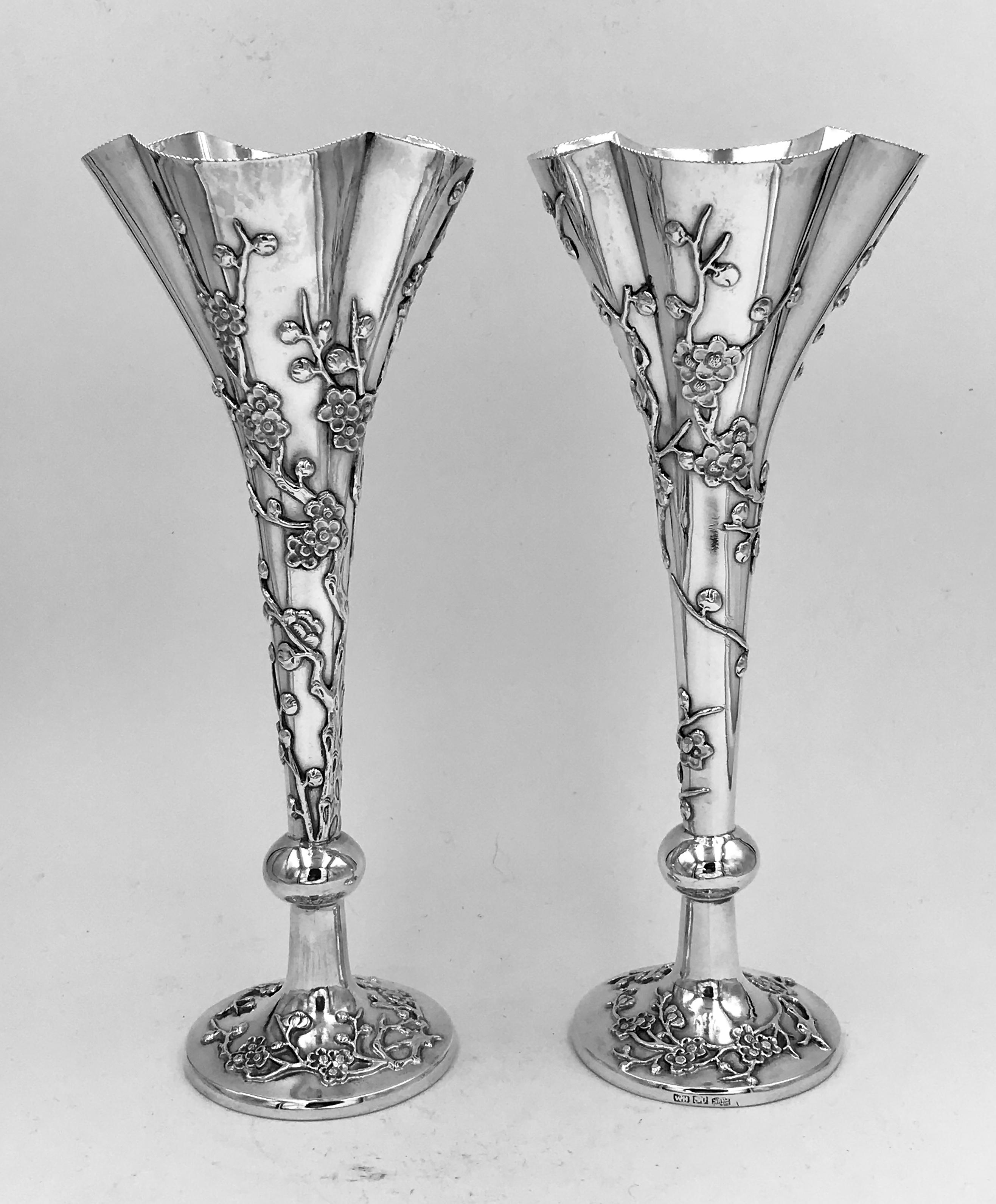 Ein Paar chinesischer Export-Silber Blumenvasen in Trompetenform, jede mit kreisförmigem Sockel und einem aufgeweiteten, geformten Oberteil. Die Vasen, die mit applizierten Prunus verziert sind, wurden um 1890 von der berühmten und einflussreichen