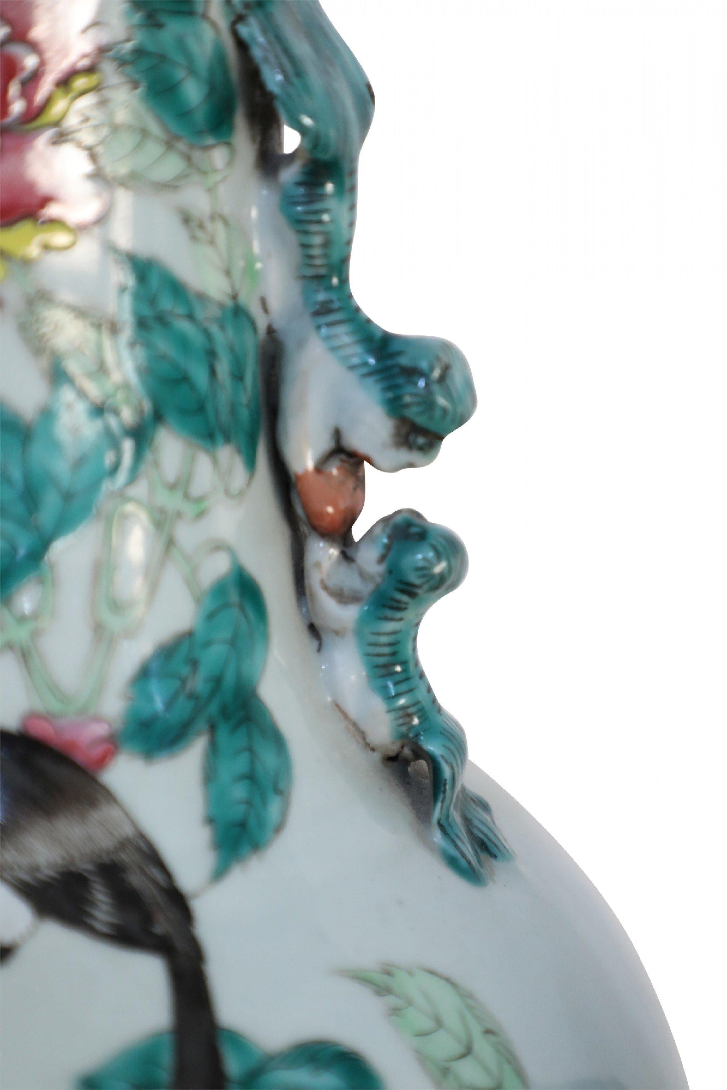 Coppia di urne antiche cinesi (fine XIX secolo) in porcellana bianca famille rose raffiguranti uccelli annidati in mezzo a un'abbondanza di rami fioriti, con manici a volute di cane foo (PREZZO A COPPIA).

Moderati segni di usura.