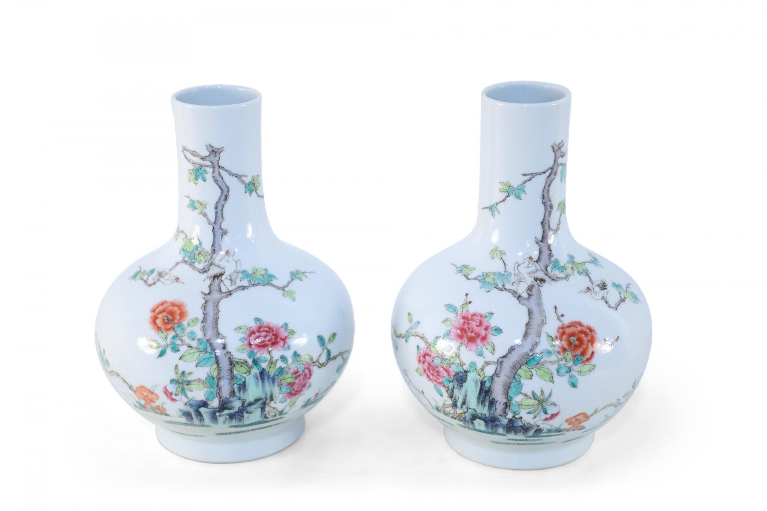 Pair of antique Chinese (late 19th century) famille rose globular porcelain vases decorated with cranes amid a tree growing from grasses surrounded by blooming pink and orange flowers on one side, and characters on the reverse (date mark on bottom,