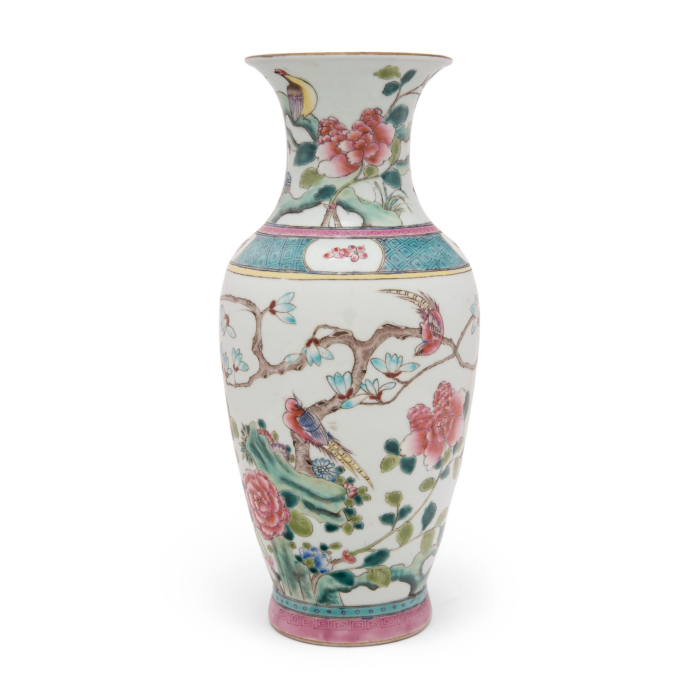 These delicate porcelain vases are made to a traditional form known as the phoenix-tail vase, defined by its tapered body, constricted neck, and elegantly flared lip. The contoured forms are finely decorated with overglaze enamels in the famille