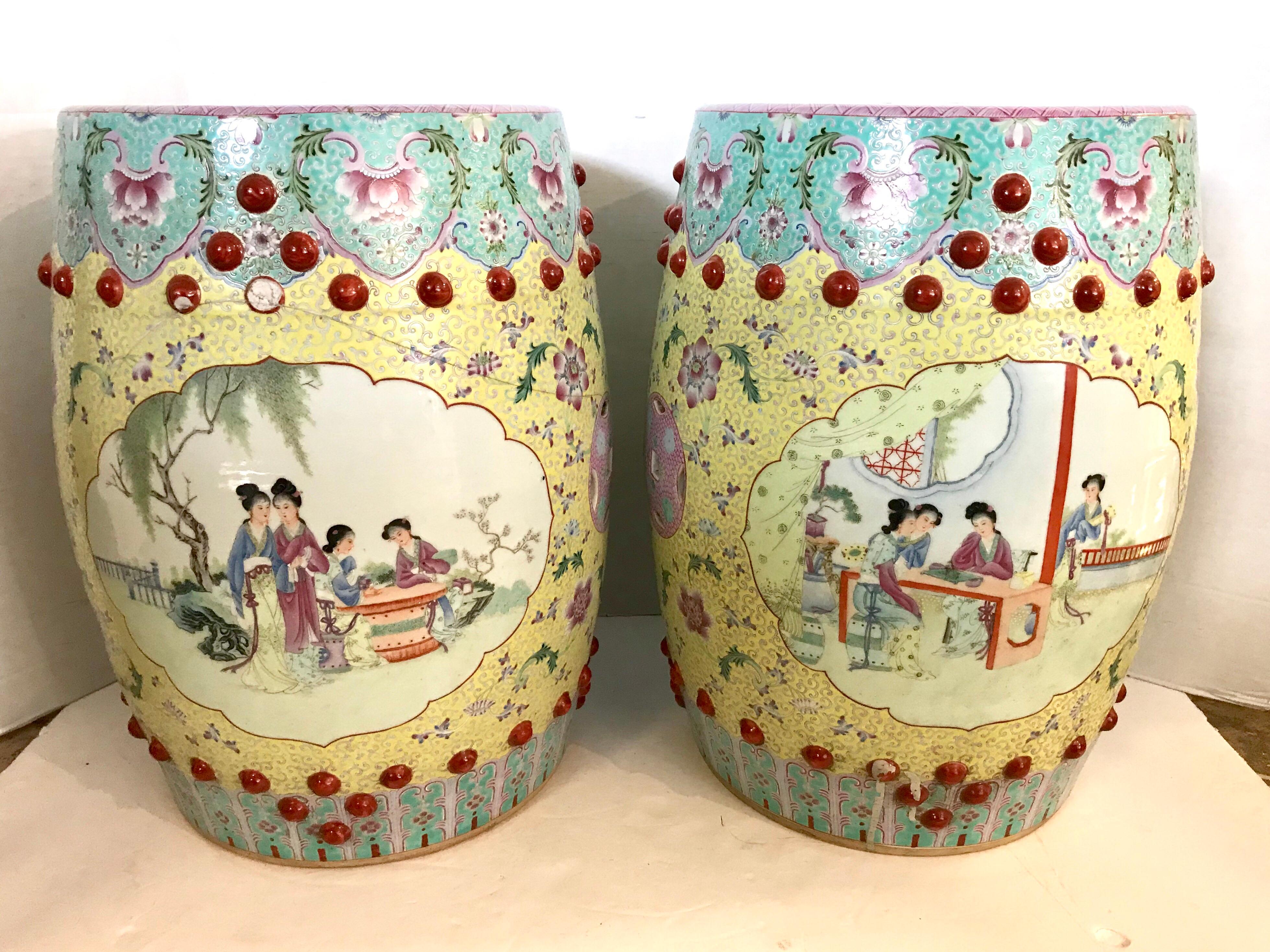 Pair of Famille rose porcelain garden seats, each hand painted with floral decorations, and raised balls, with Chinese figures depicting court life. The pink medallions on the sides and top are pierced. One is cracked, see pic.