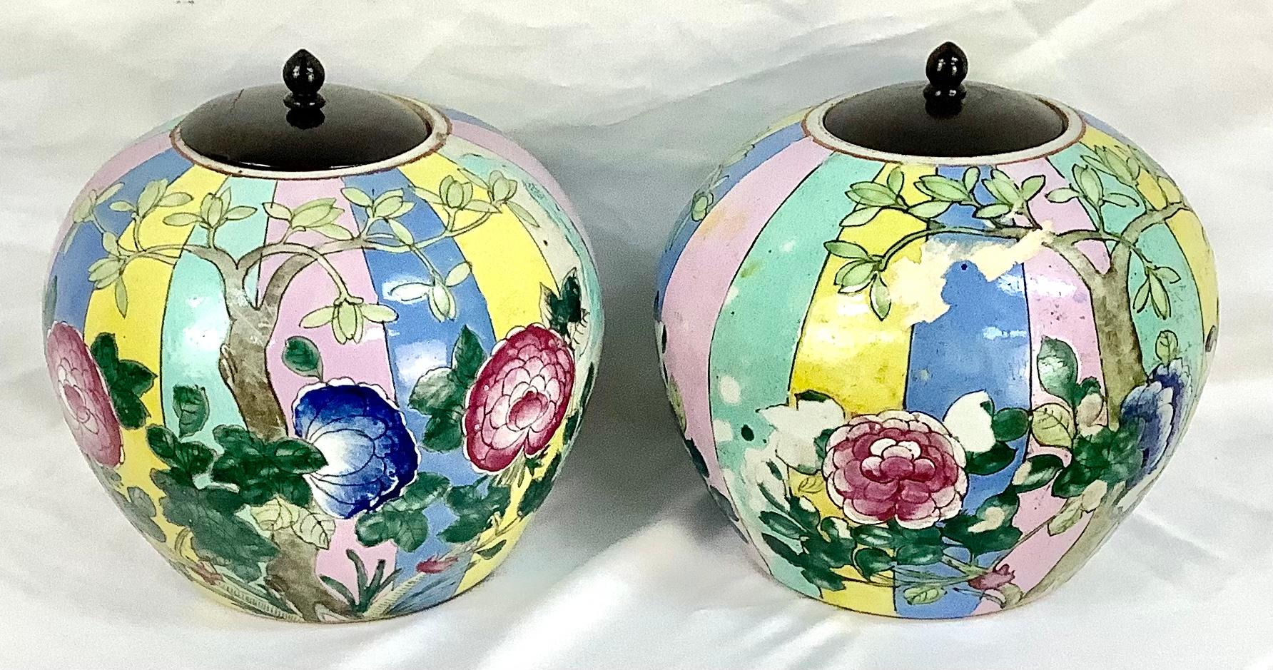 Pair of Chinese Famille Rose porcelain ginger jars with lid. Beautiful floral motif with colors of pinks, greens, yellows and blues with black wooden lids. In good condition. 

Measures: 8