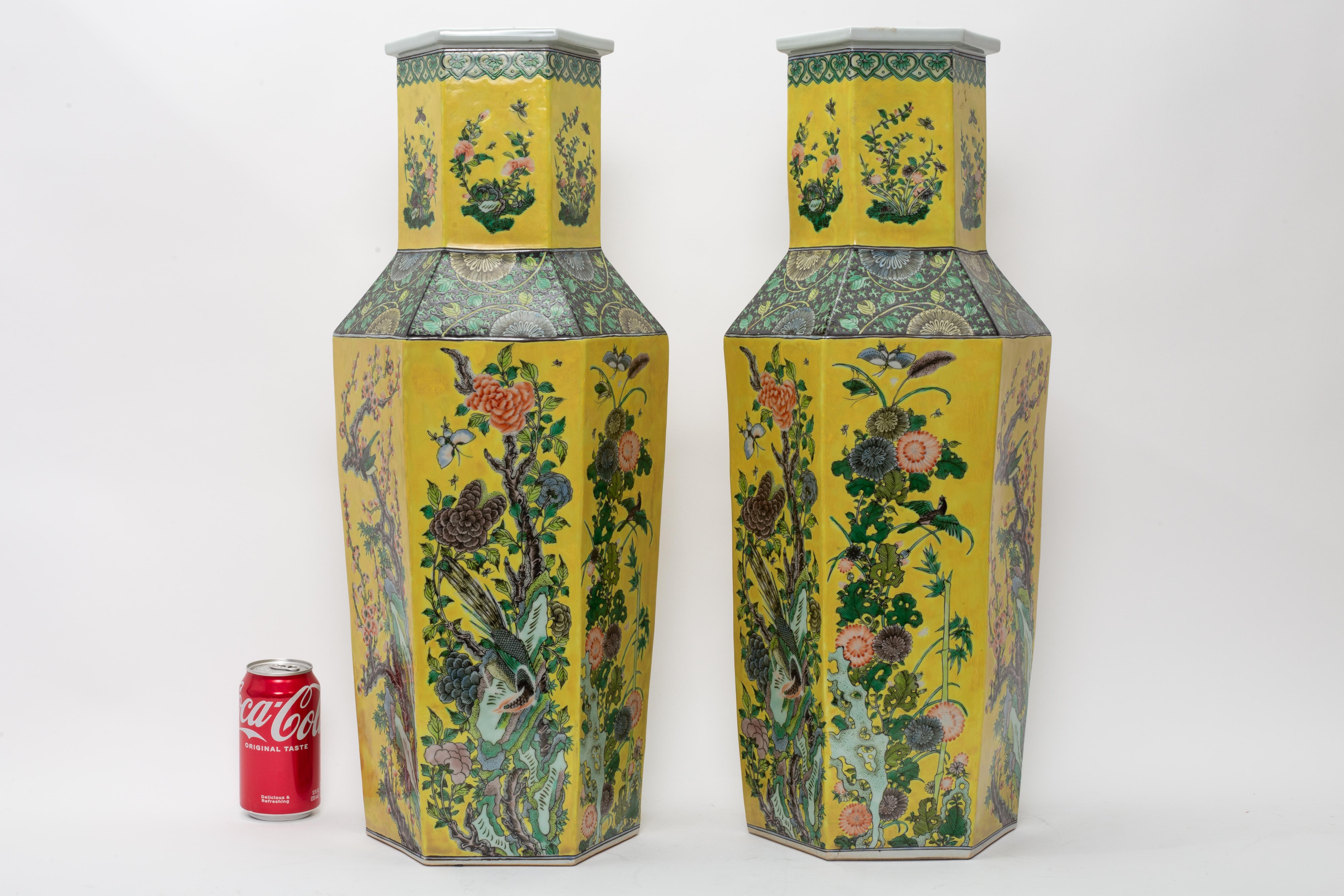 Paire de vases hexagonaux en porcelaine de Chine décorés en famille rose sur fond jaune

La paire est formée de corps hexagonaux hauts qui s'élèvent vers de larges épaules et des cols droits terminés par des rebords évasés. Chaque facette du corps