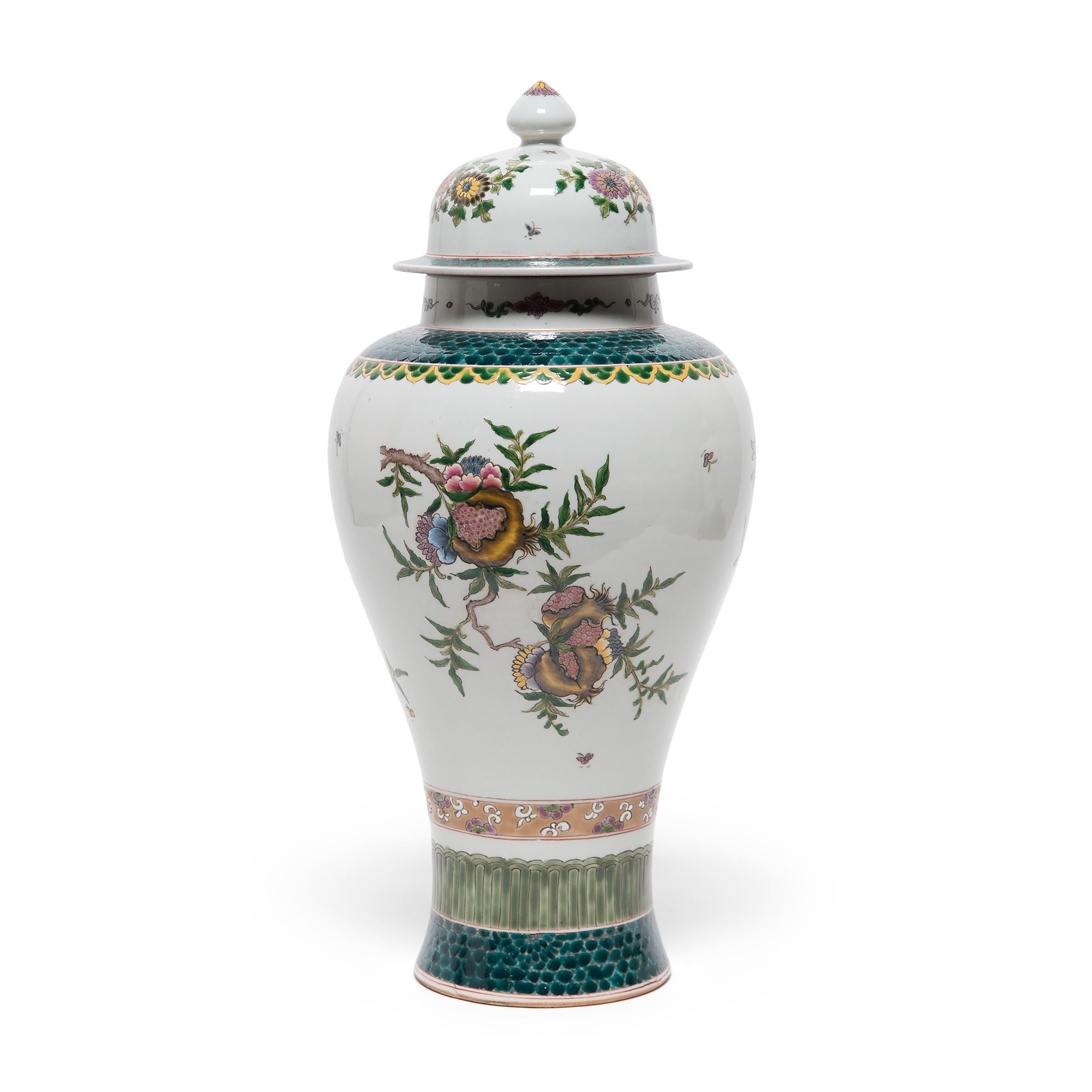These elegant porcelain baluster jars are distinct for their wonderfully sculptural shape, defined by a rounded body that tapers gracefully to a narrow, flared base. The pair is decorated with overglaze enamels in the famille verte style, using a