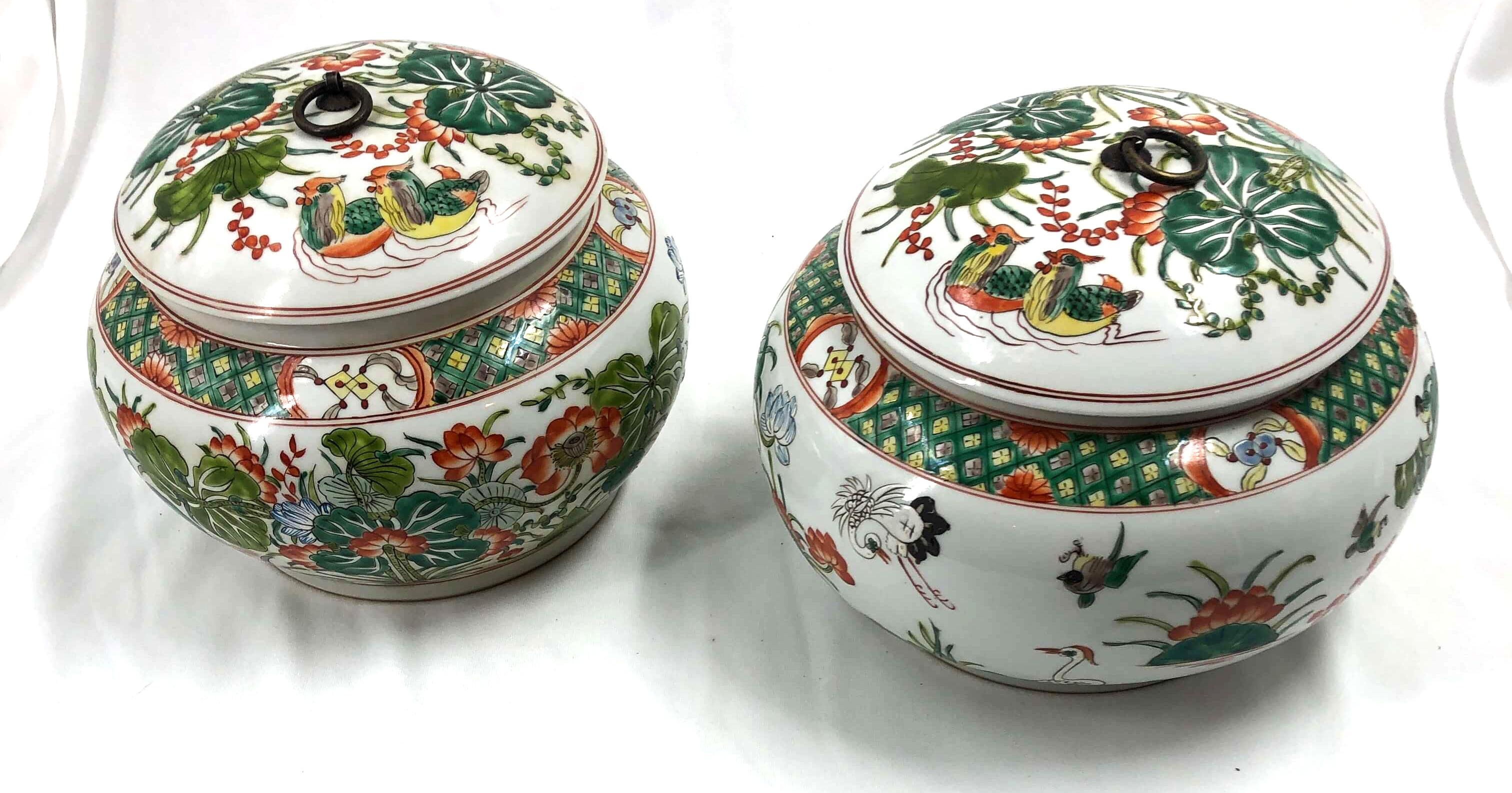 Pair of Chinese export Famille Verte round covered vases, hand painted and decorated with water scenes of grass, flowers, and fowl.