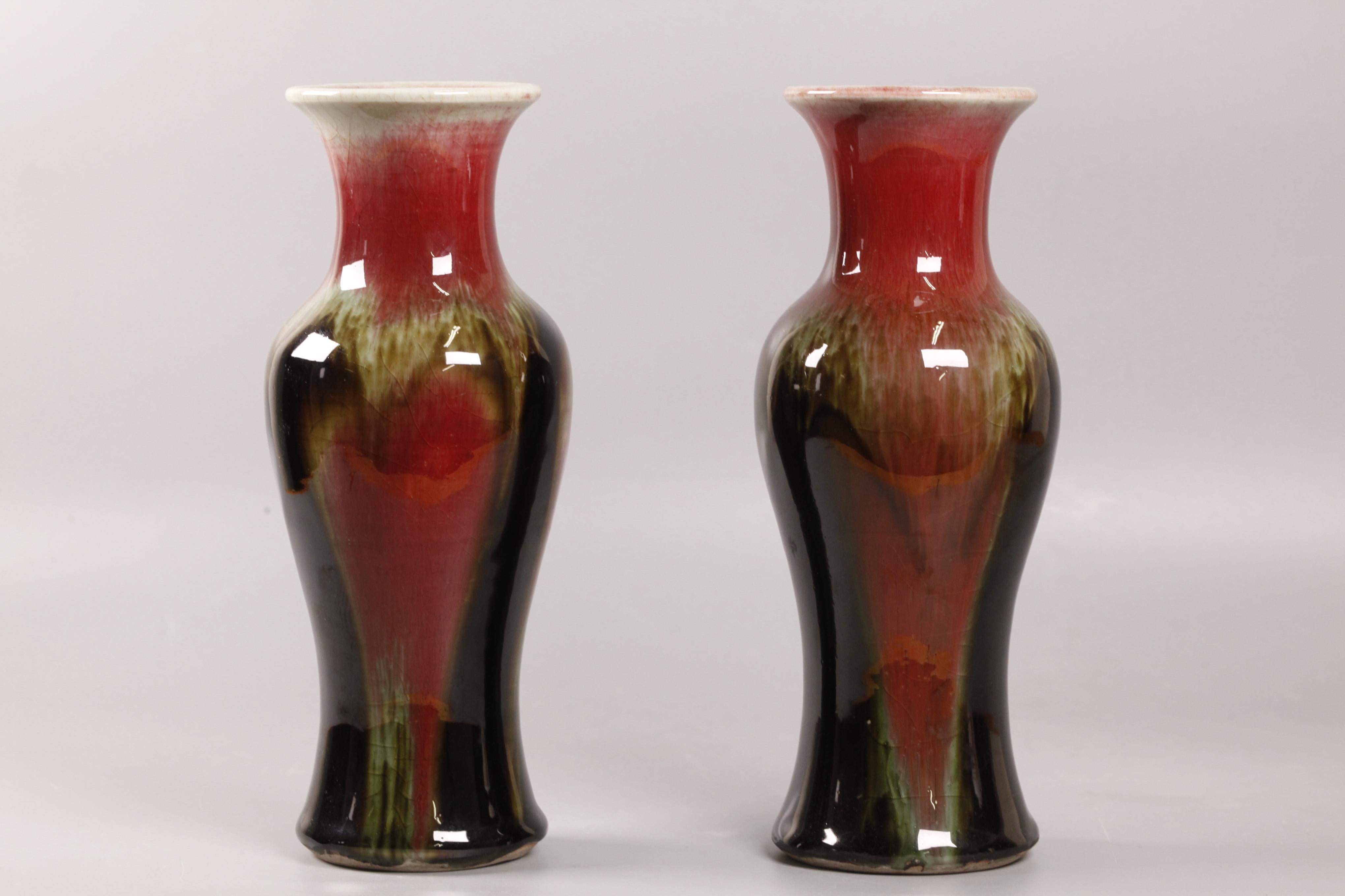 les deux vases sont décorés de craquelures et recouverts d'une glaçure rouge avec des champignons et des stries vertes 
