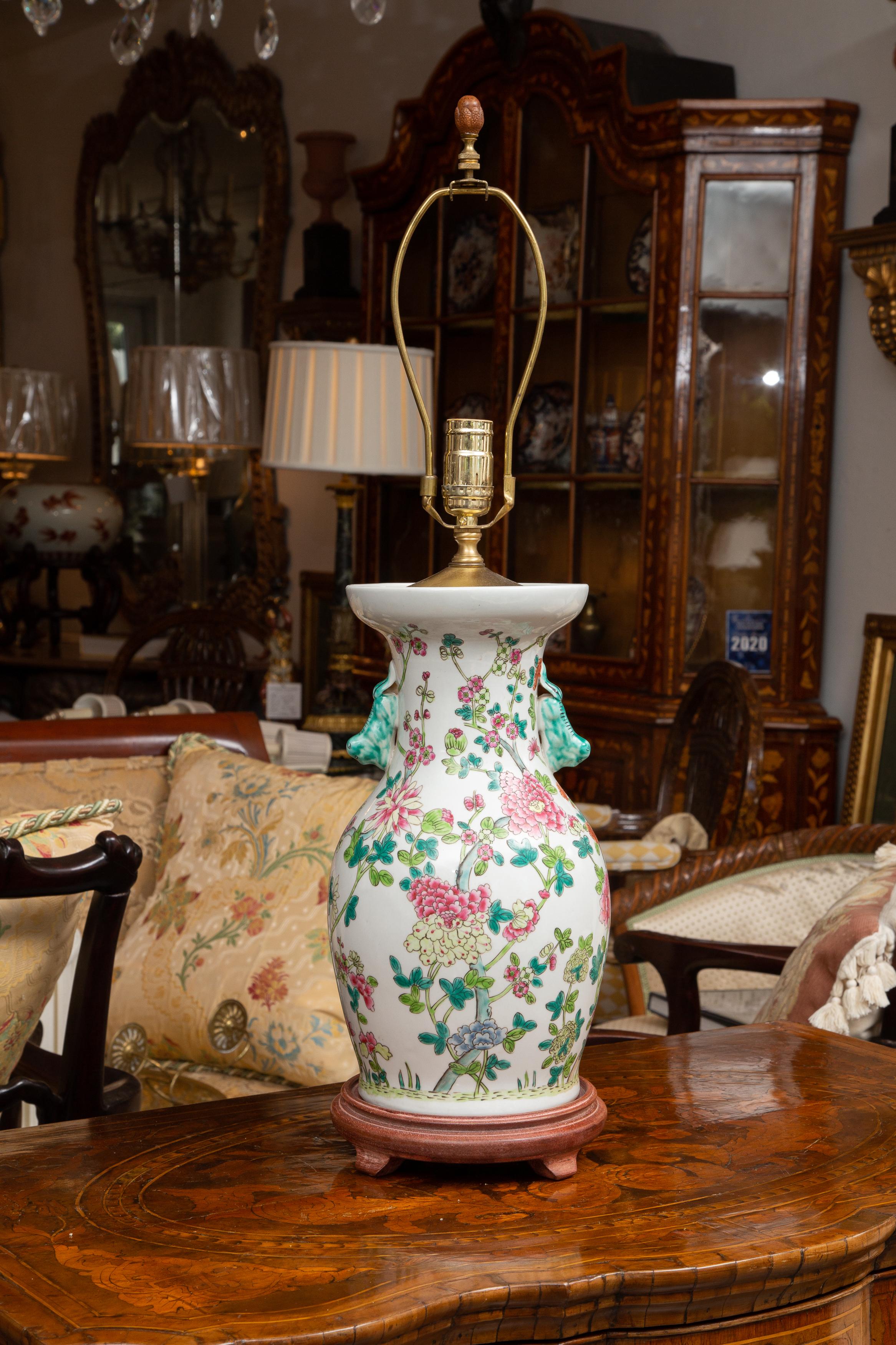 This is a lovely pair of Chinese lamps painted overall with Rose Medallion colors of pinks, greens and blues, situated on a stained wood base.