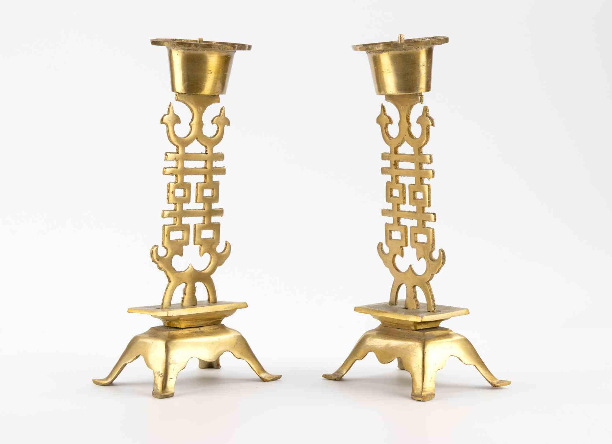 Una bella coppia di candelabri in bronzo dorato del primo periodo della Repubblica, ciascuno dei quali poggia su quattro gambe strombate che sostengono una base quadrata. Il gambo, che si erge dalla base, è traforato con un disegno traforato