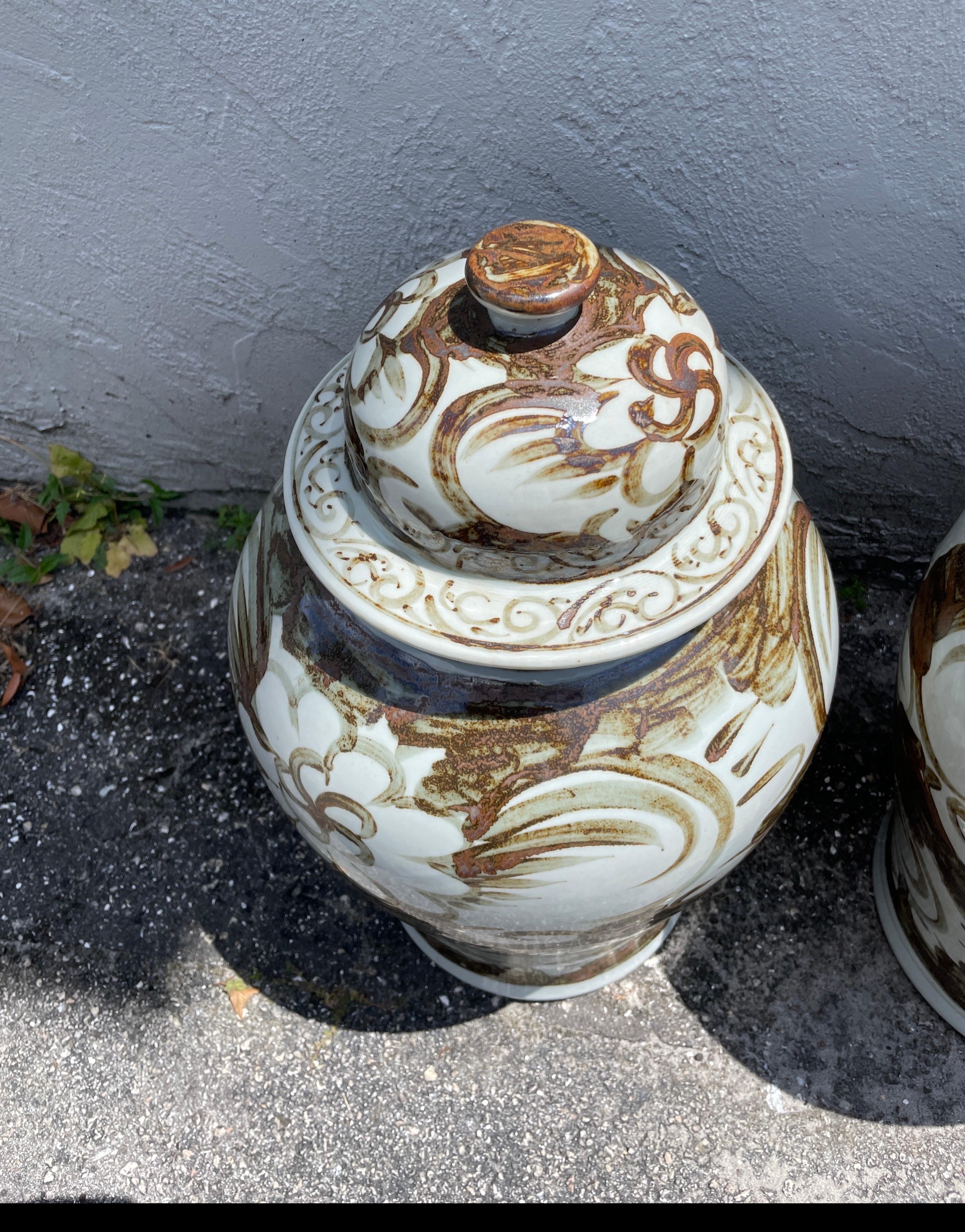 Unique pair of Chinese ginger jars in rare brown and white colorations. A very nice overall pattern design. Perfect size for most settings.