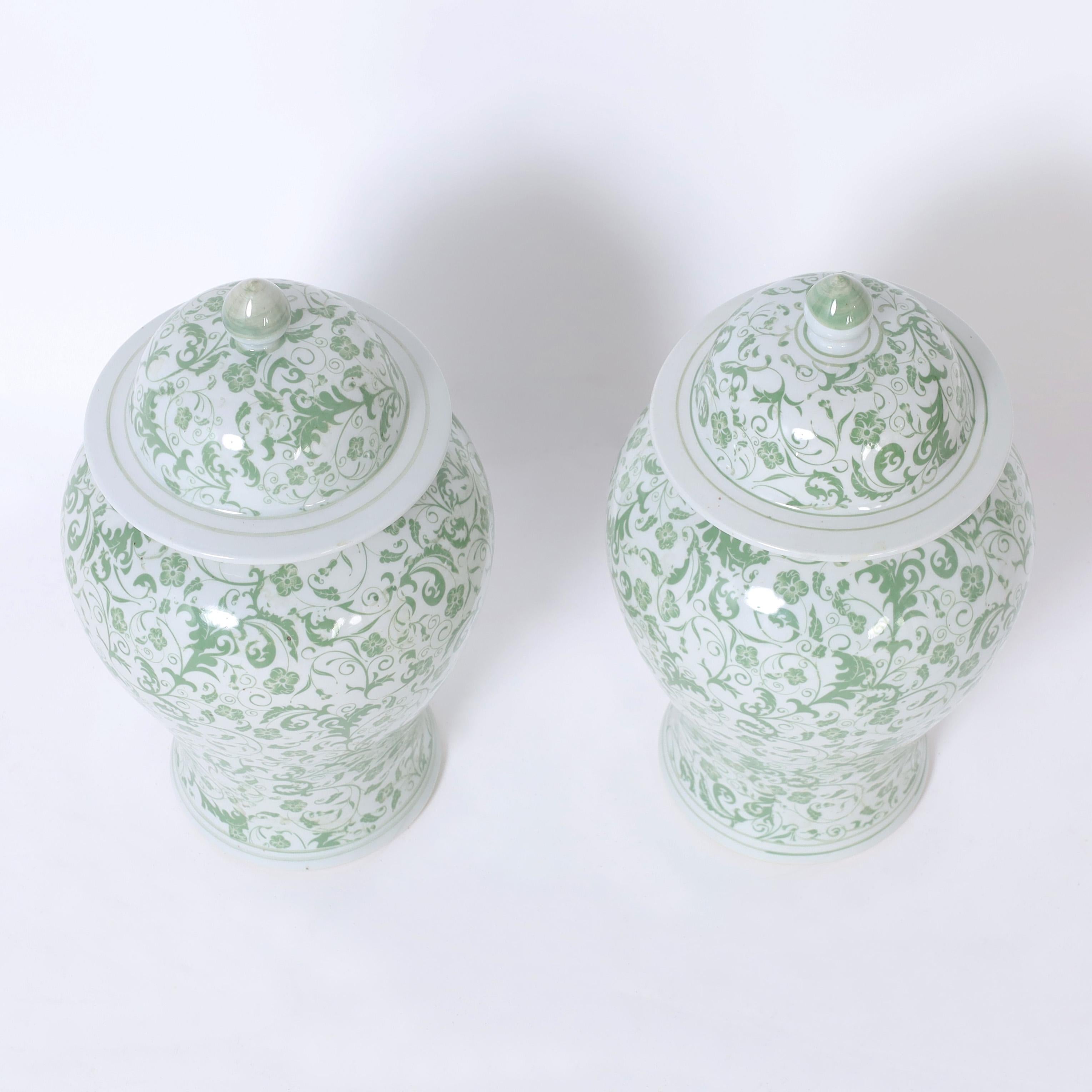 Lofty pair of Chinese porcelain ginger jars hand crafted in classic form and hand decorated in delightful green and white floral designs.