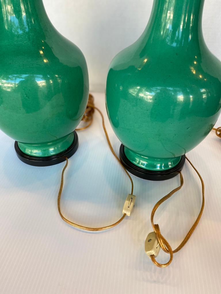 This pair of bottleneck vases made into lamps have the wonderful color of green from the 1970s
brass metal and wooden black bases.
  