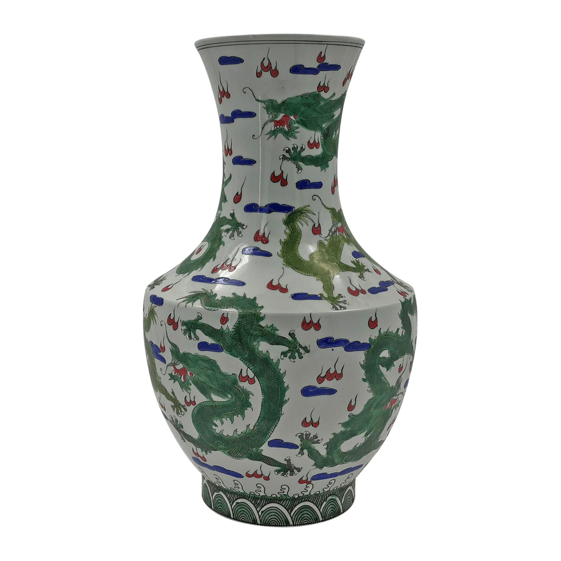 Pair of large Chinese Hu-shaped vases decorated with frolicking dragons in a field.