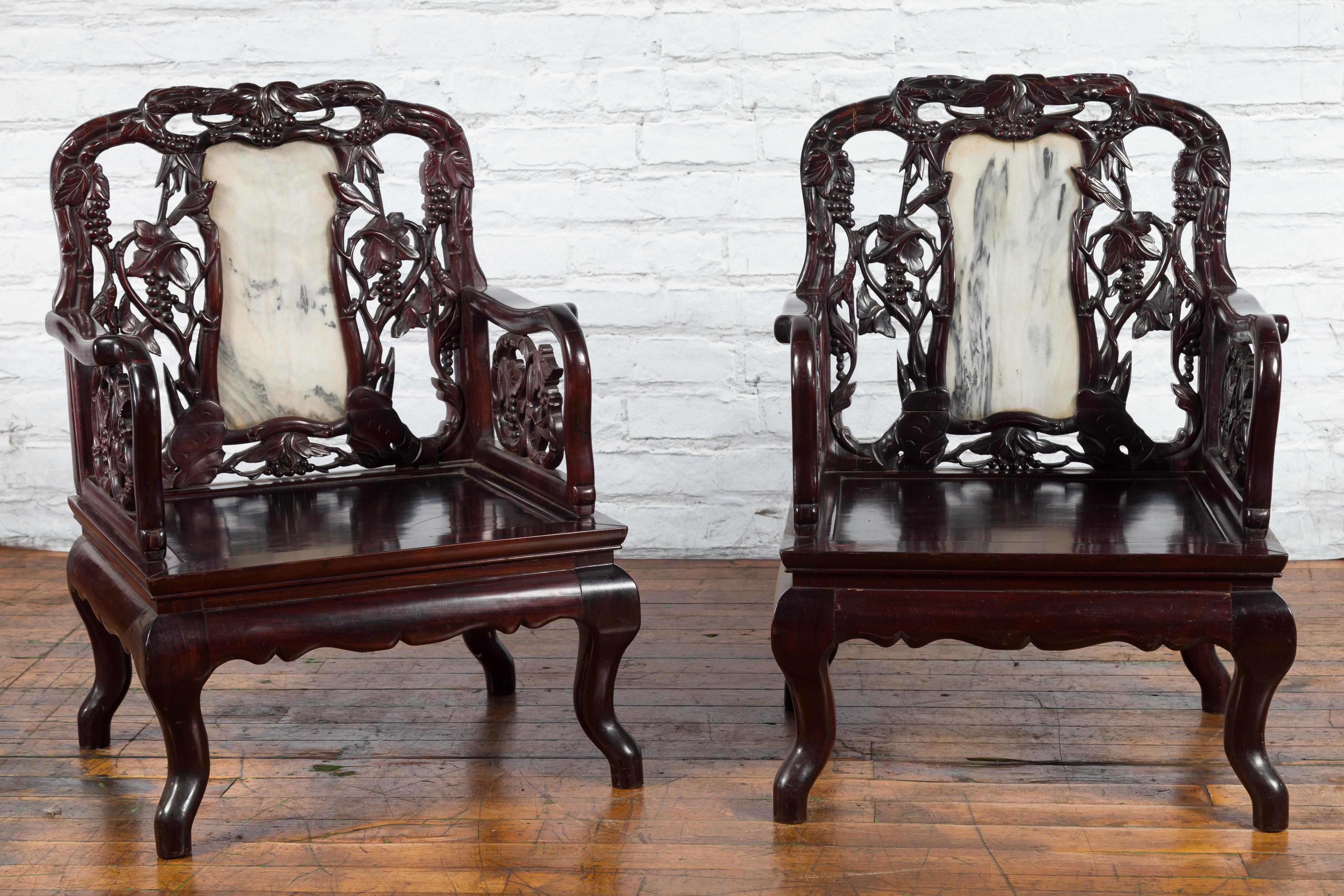 A pair of Chinese hand carved rosewood armchairs from the early 20th century with inset marble splats and dark patina. We currently have two pairs available, price and sold per pair. Possibly used by Chinese aristocrats, these rosewood armchairs
