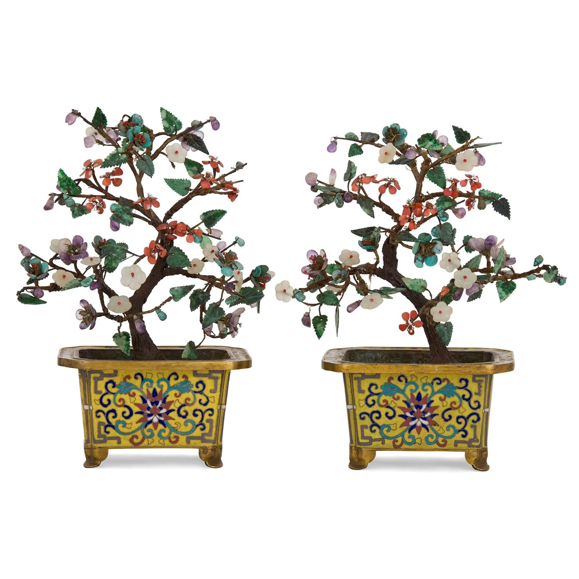 Pair of Chinese hardstone, jade and cloisonné enamel flower tree models
Chinese, 20th Century
Height 24cm, width 18cm, depth 10cm

This pair of charming Chinese models depicts flower trees and is crafted from a large array of high quality materials.