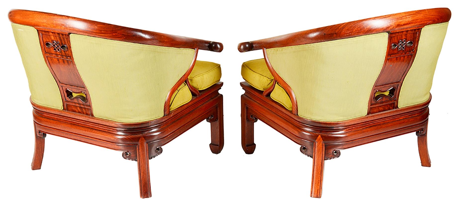 A late 19th-early 20th century pair of Chinese hardwood horse shoe style armchairs, each with carved decoration to the splats, green upholstered back and seats and raised on square section legs.