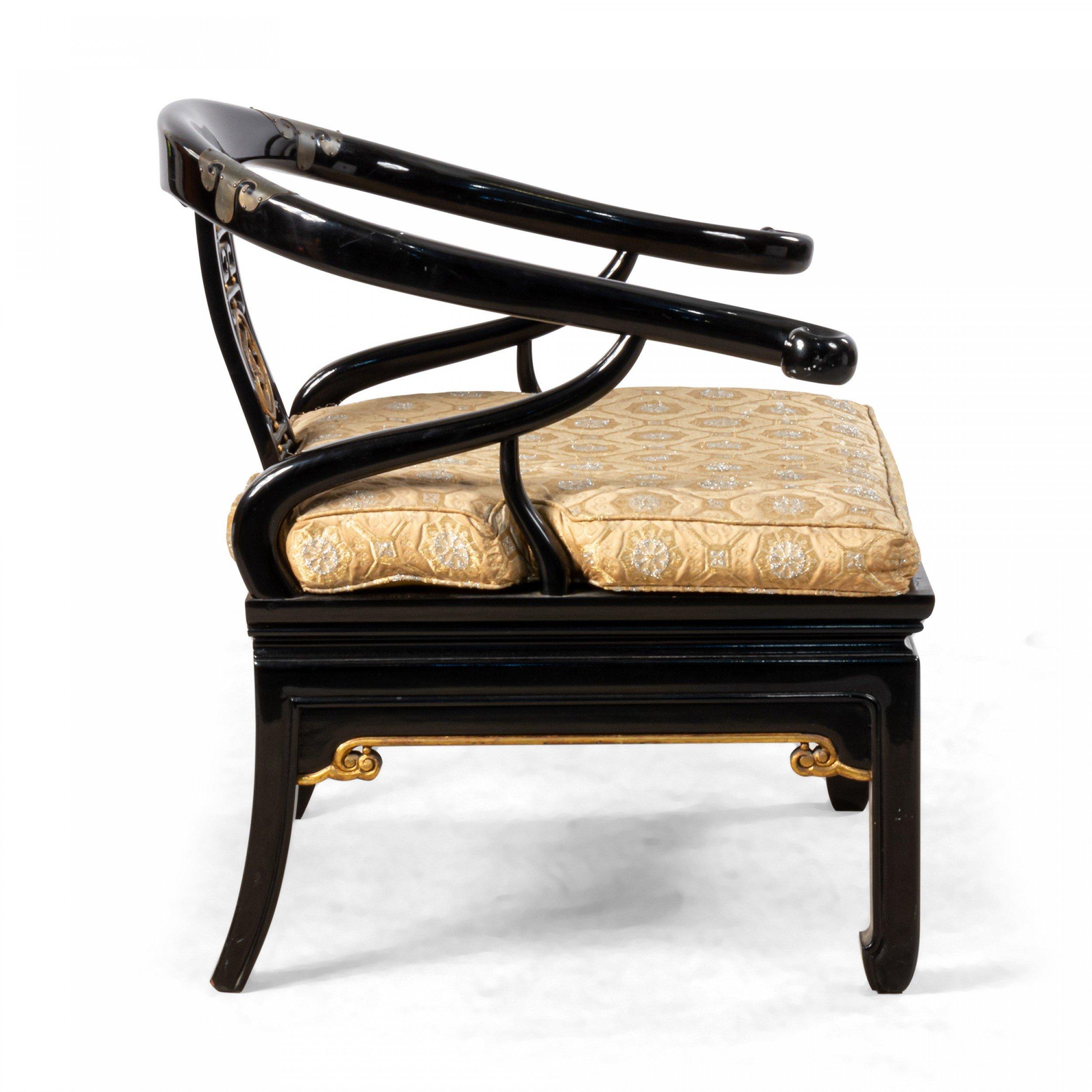 Pair of Chinese Regency style lacquered horse shoe armchairs in the style of James Mont with gilt ornamentation along frame and an elaborate decorative pierced back slat.