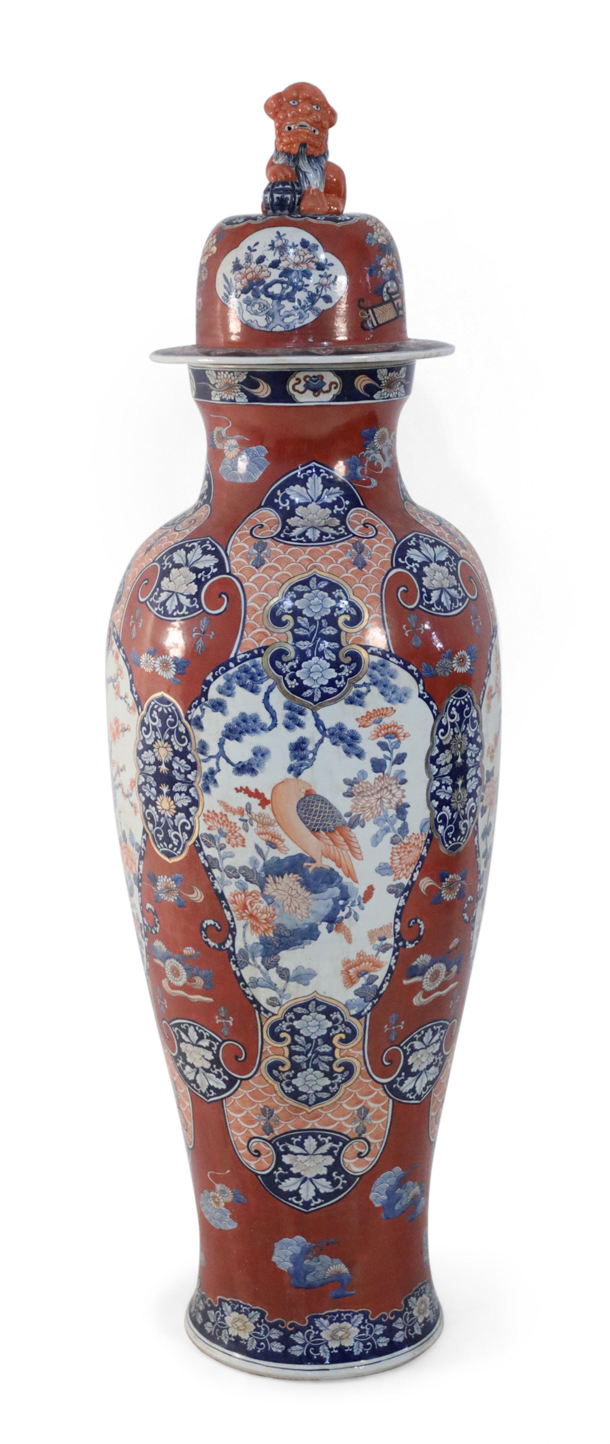 COPPIA di vasi da terra cinesi monumentali con coperchio in porcellana che celebrano la ceramica Imari giapponese sia nella tavolozza che nella decorazione, con medaglioni centrali di uccelli appollaiati su alberi in fiore, circondati da disegni