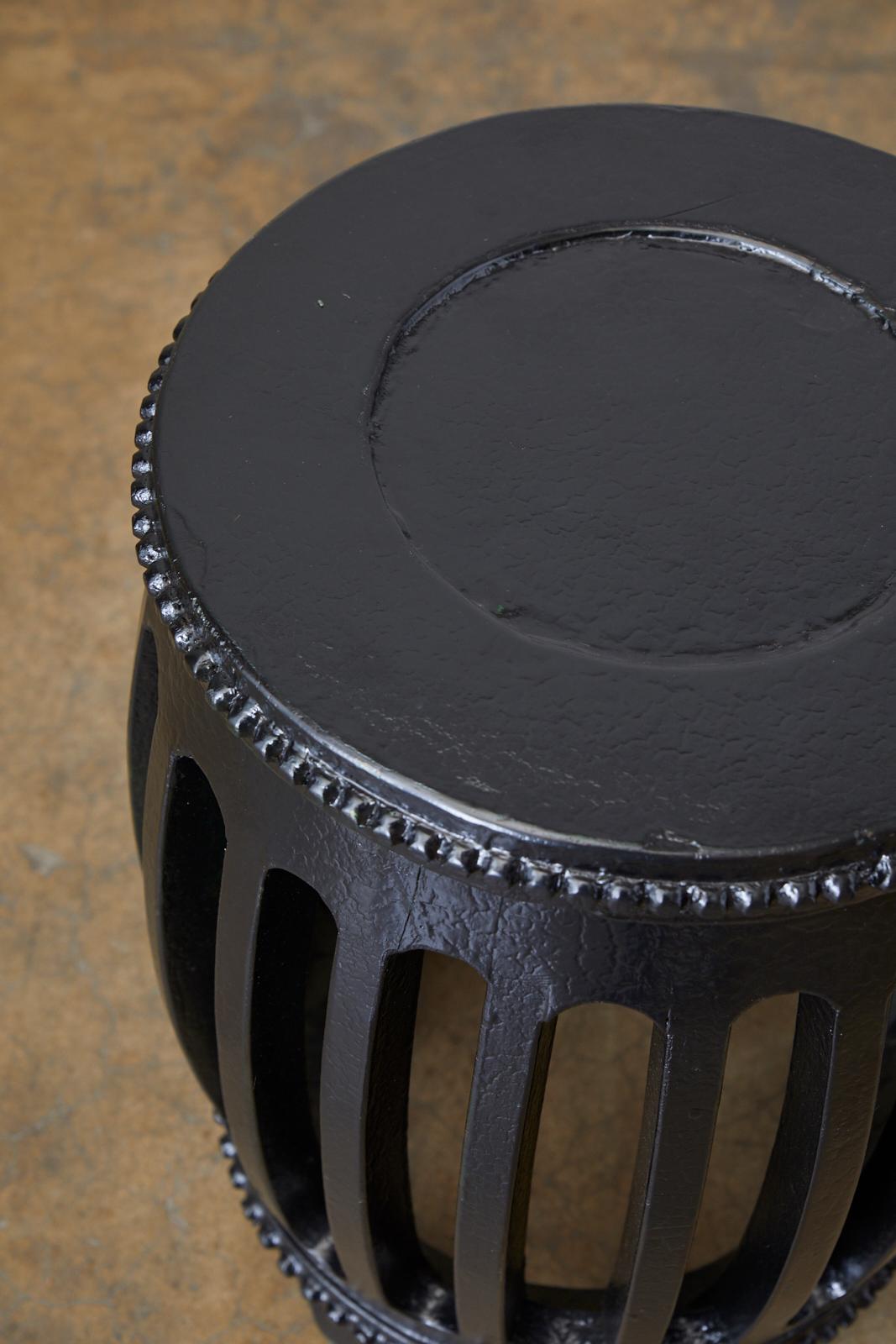 Matching pair of Chinese export wooden garden stools, drinks table, tabourets, or drum tables. Featuring a black lacquered finish with a craquelure patina. The round forms have open slats on the sides and decorative hobnail dots ground the top and