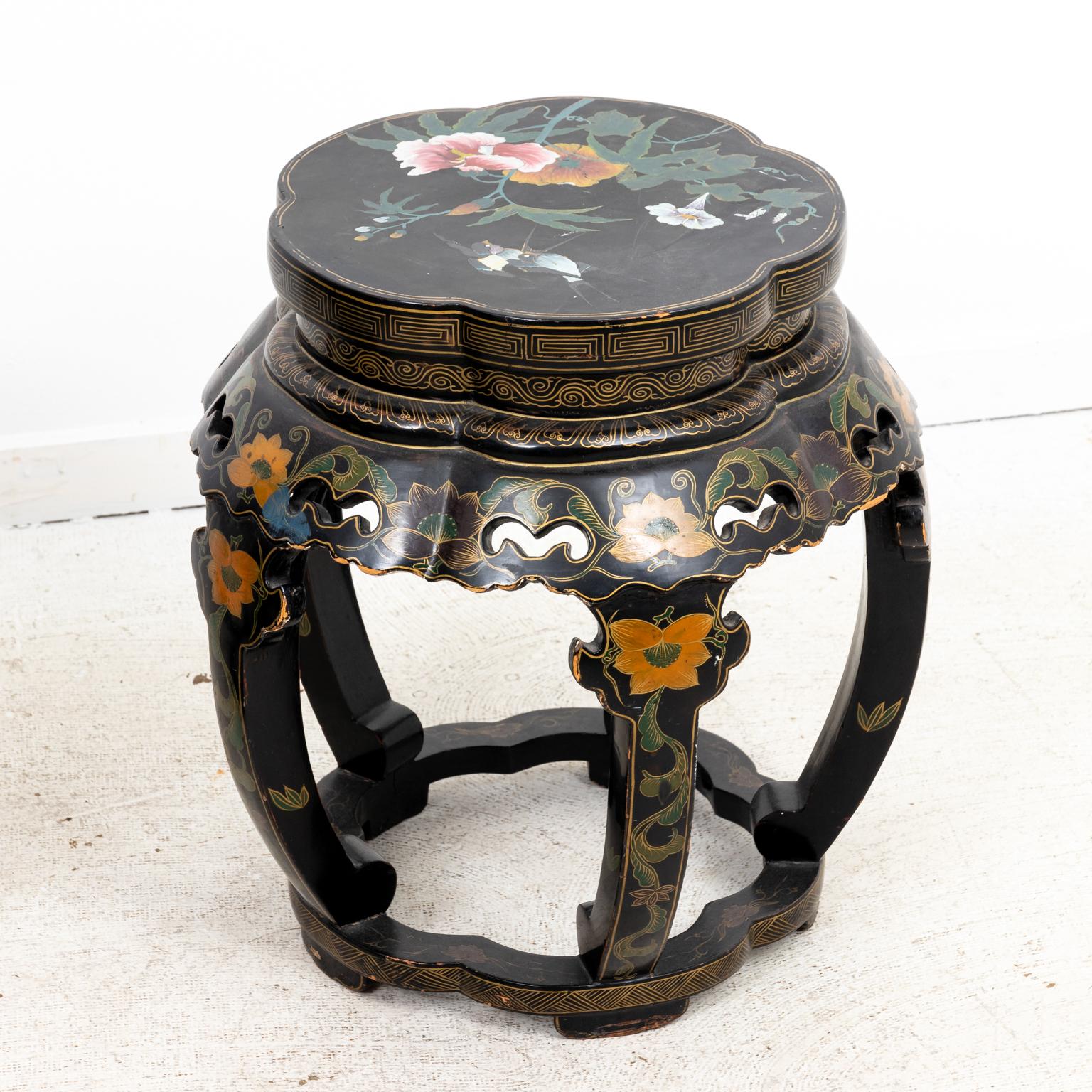 Pair of Chinese lacquered stools, heavily decorated with floral motifs and a carved skirt. The piece is also ornamented with Greek key trim and birds. Please note of wear consistent with age including minor paint loss and finish loss.