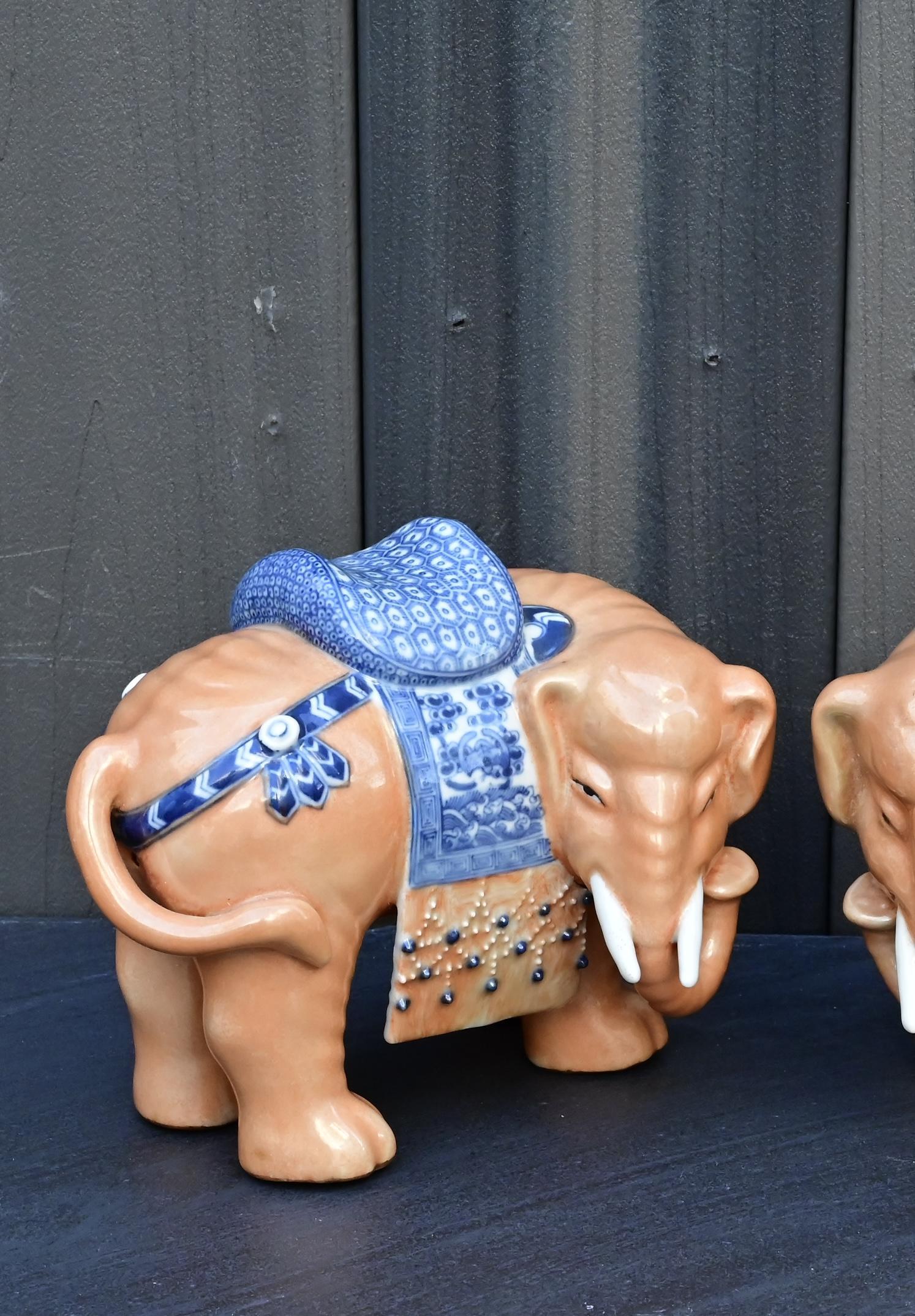 Il s'agit d'une belle paire d'éléphants en porcelaine de Chine, datant de la fin de la période Qing au début de la République (début du 20e siècle). Chaque éléphant est magnifiquement fabriqué à la main et peint avec des panneaux de selle bleus et